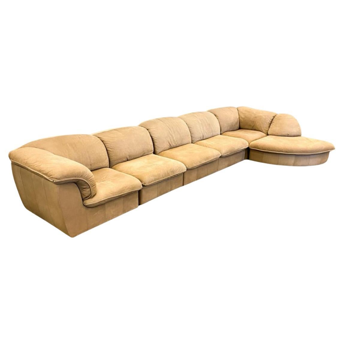Mid century German tan suede leather puffy modular sofa by Laauser, made in Germany. The sofa consists of (6) sections (2) corners (3) middle sections and (1) curve. The sofa is modular so all pieces are not attached and can be reconfigured to a