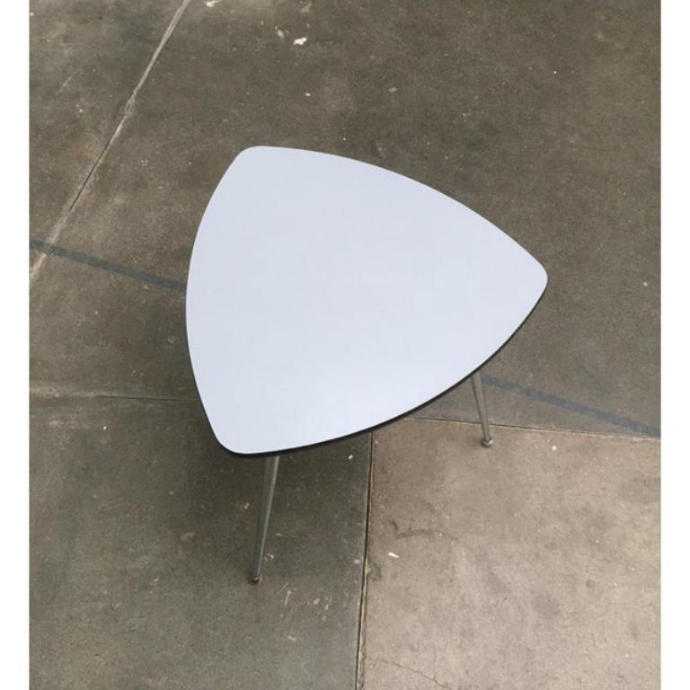 Rare table Mauser en tube d'acier de forme et de couleur particulières.

Outre la forme triangulaire caractéristique, le revêtement bleu-gris des surfaces de la table attire particulièrement l'attention. Le bord en plastique noir contraste avec ce