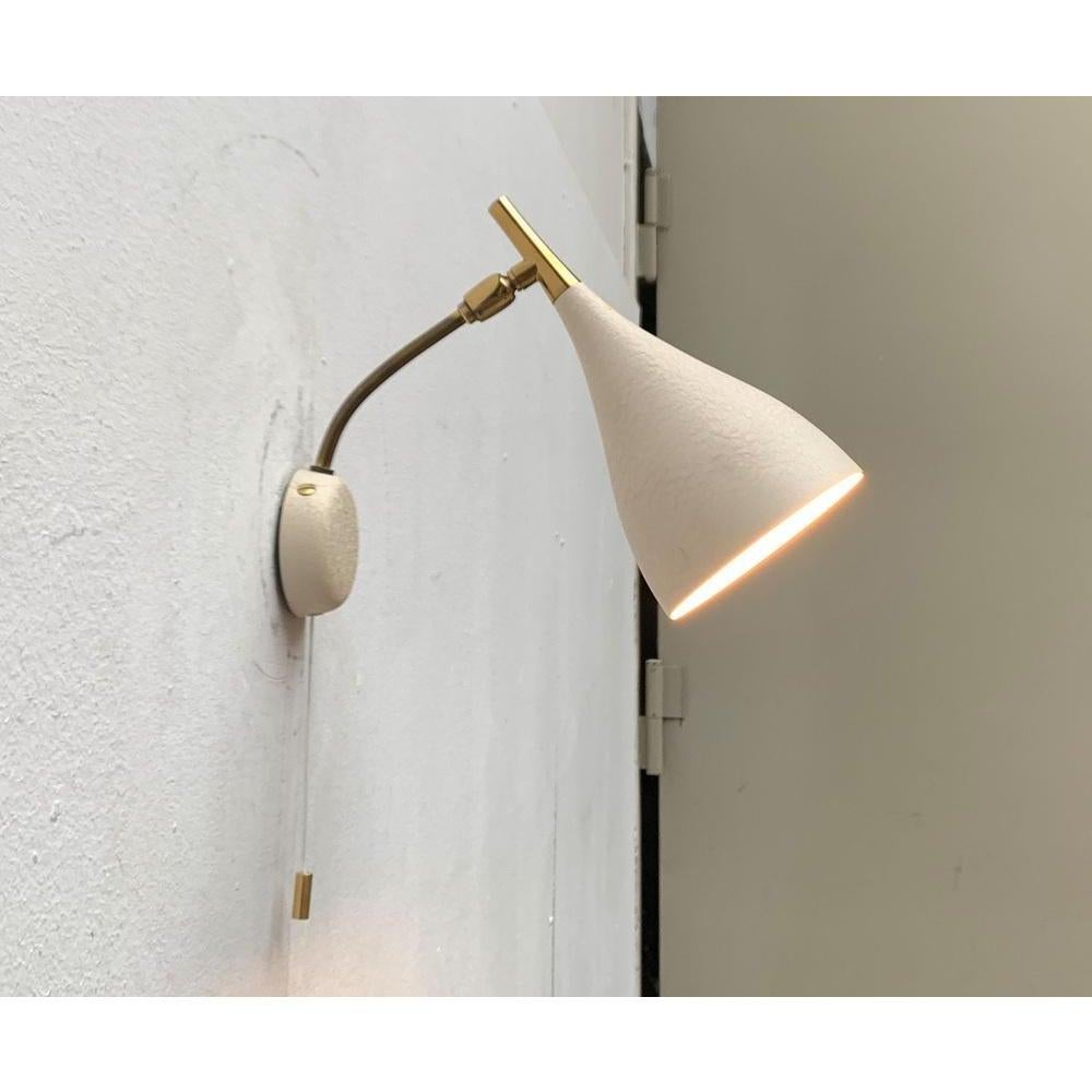 Lampada da parete del Mid Century di Cosack. Questi disegni sono spesso erroneamente attribuiti a Louis Kalff.

Un design in filigrana. La tonalità chiara, finemente realizzata, mostra la forma di una borsa. Il paralume vero e proprio è ricoperto da