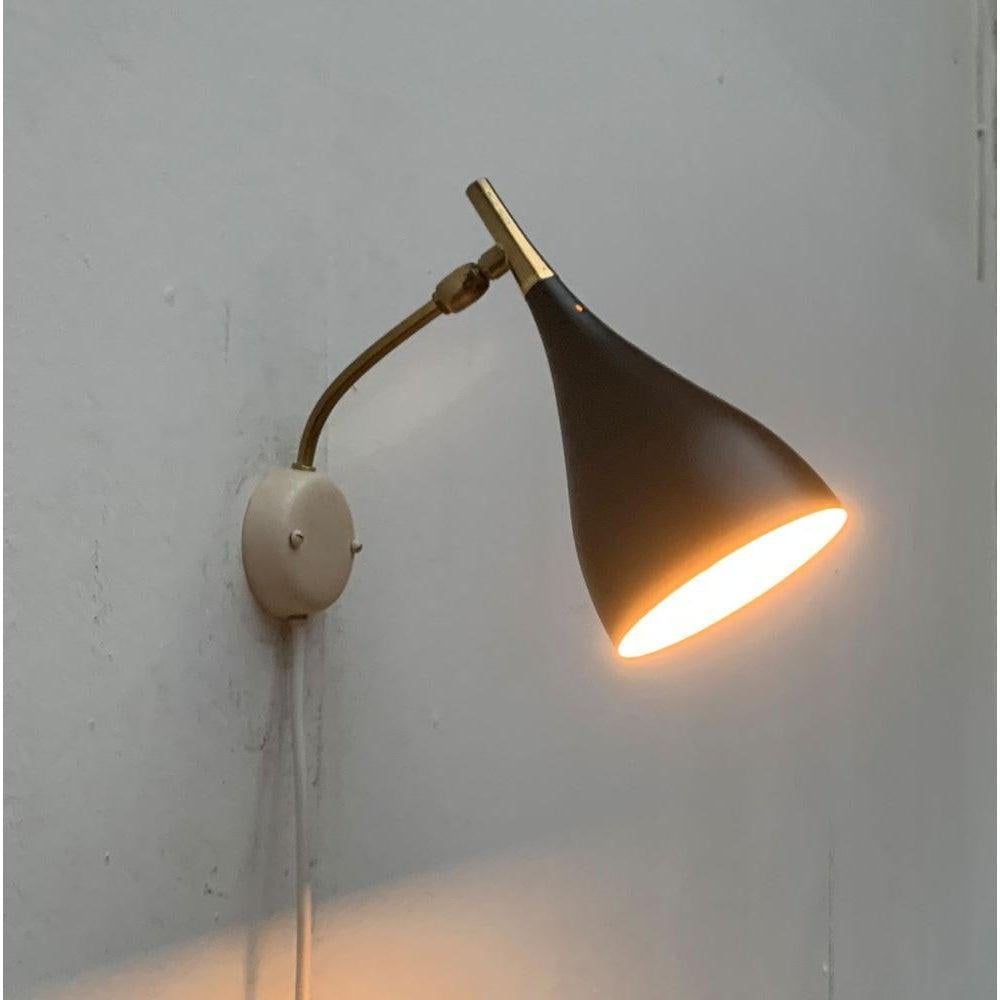 Lampada da parete di metà secolo di Cosack. Questi disegni sono spesso erroneamente attribuiti a Louis Kalff.

Un design in filigrana. Il paralume, finemente realizzato, ha una forma a cono. Il paralume vero e proprio è rifinito in nero e si