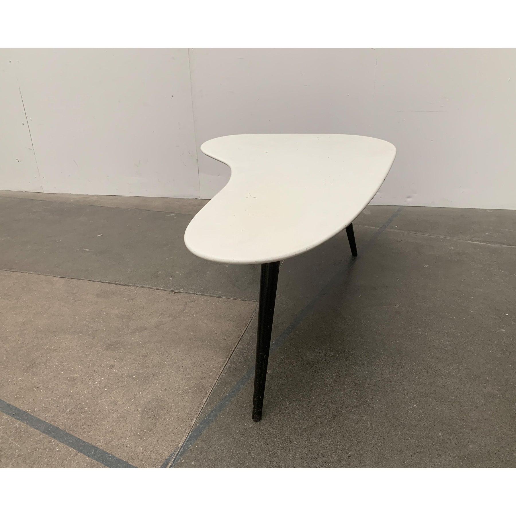 Elegante tavolino da caffè del Mid Century in bianco e nero.

Particolarmente accattivante è la forma organica del piano del tavolo. Il piano è molto spesso e ha un ampio bordo smussato. Colpiscono le gambe coniche del tavolo. Queste sono rifinite