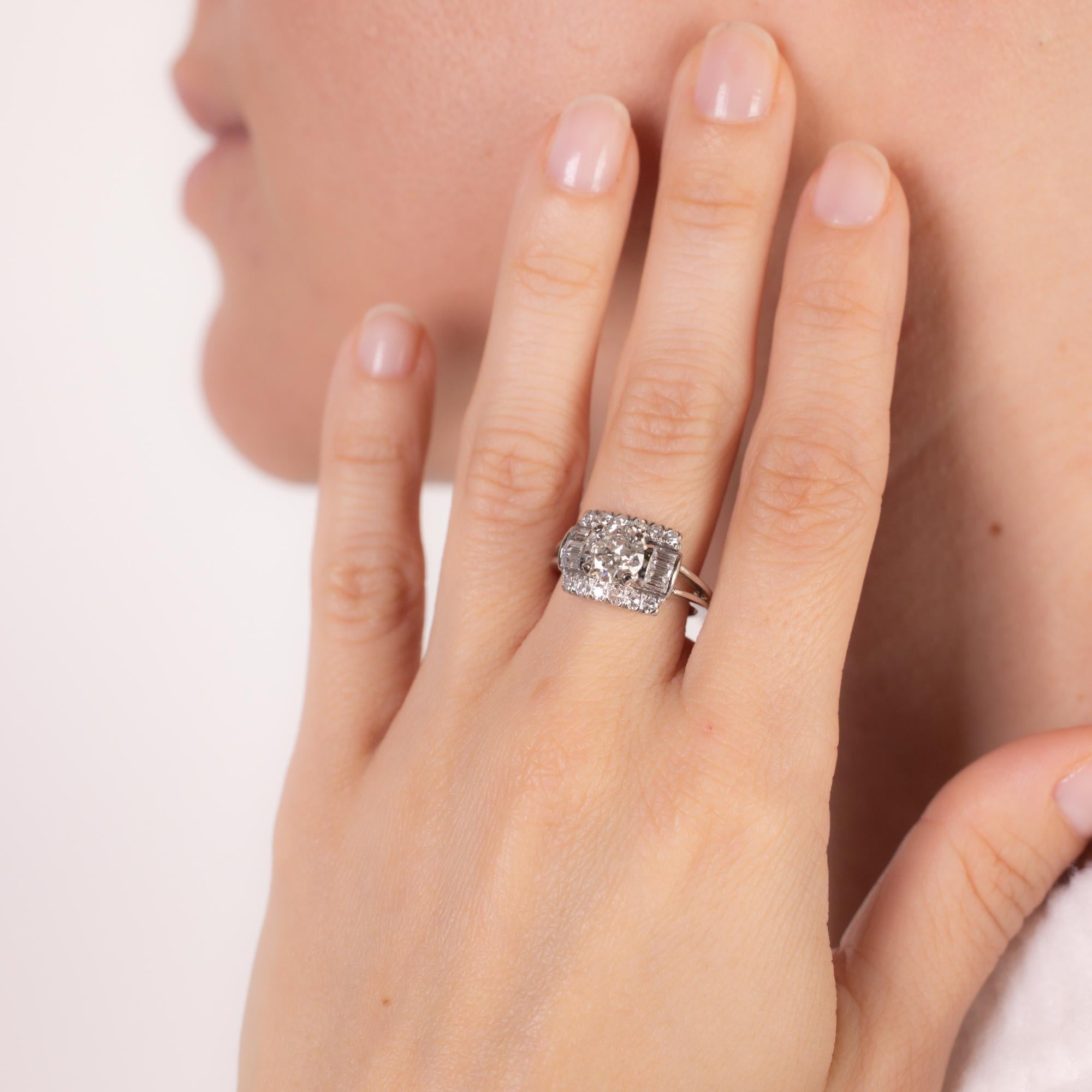 This elegant mid-century platinum ring showcases a GIA-certified 1.25-carat round brilliant cut diamond, I color, SI2 clarity, framed by 18 baguette and single-cut diamonds totaling approximately 0.70 carats, E-F color, VS clarity. A timeless design