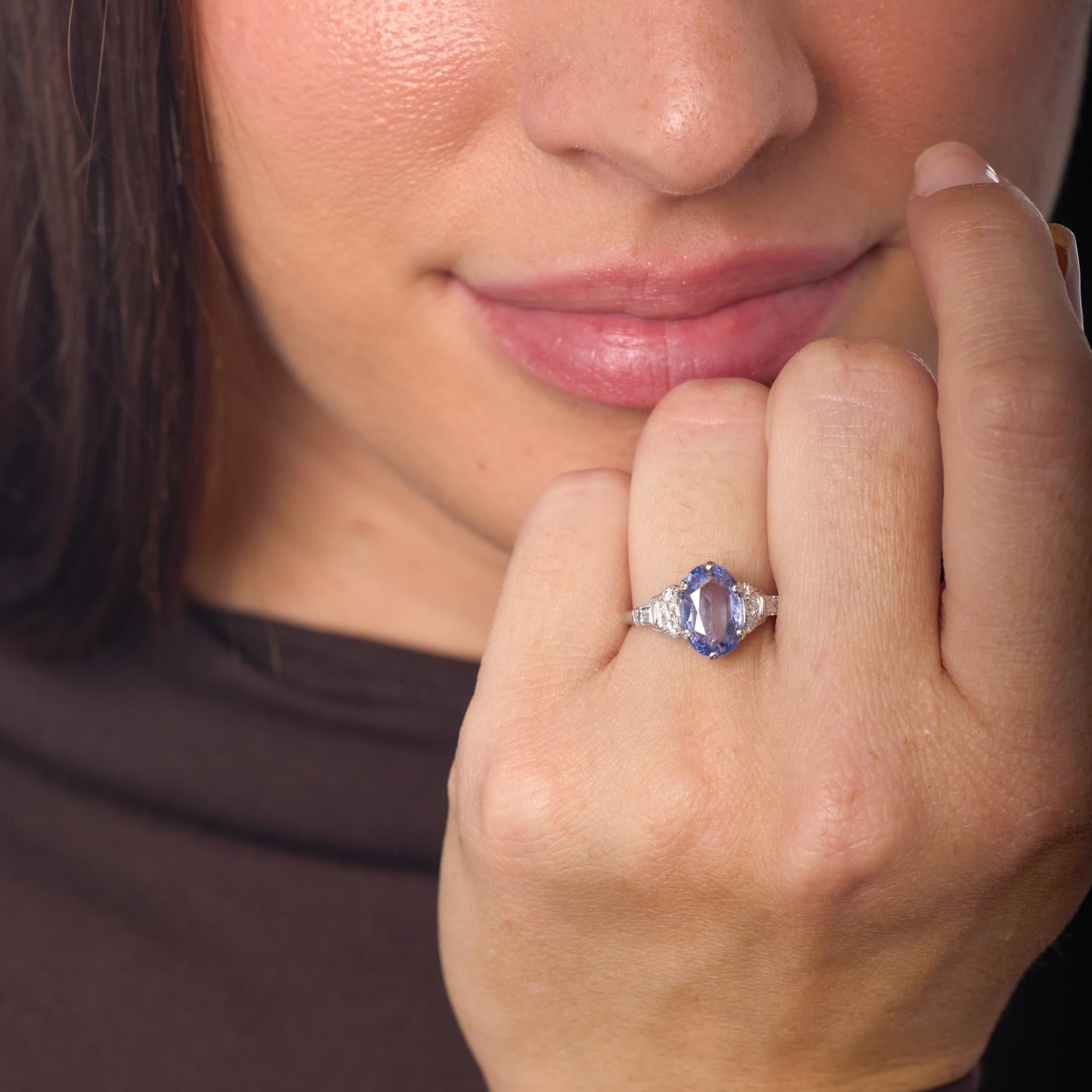 Questo anello in platino del Mid Century è incentrato su un vivido zaffiro senza calore, la cui tonalità blu-viola irradia una notevole profondità e purezza naturale. Il grazioso taglio ovale attira lo sguardo verso il suo nucleo luminoso, mentre