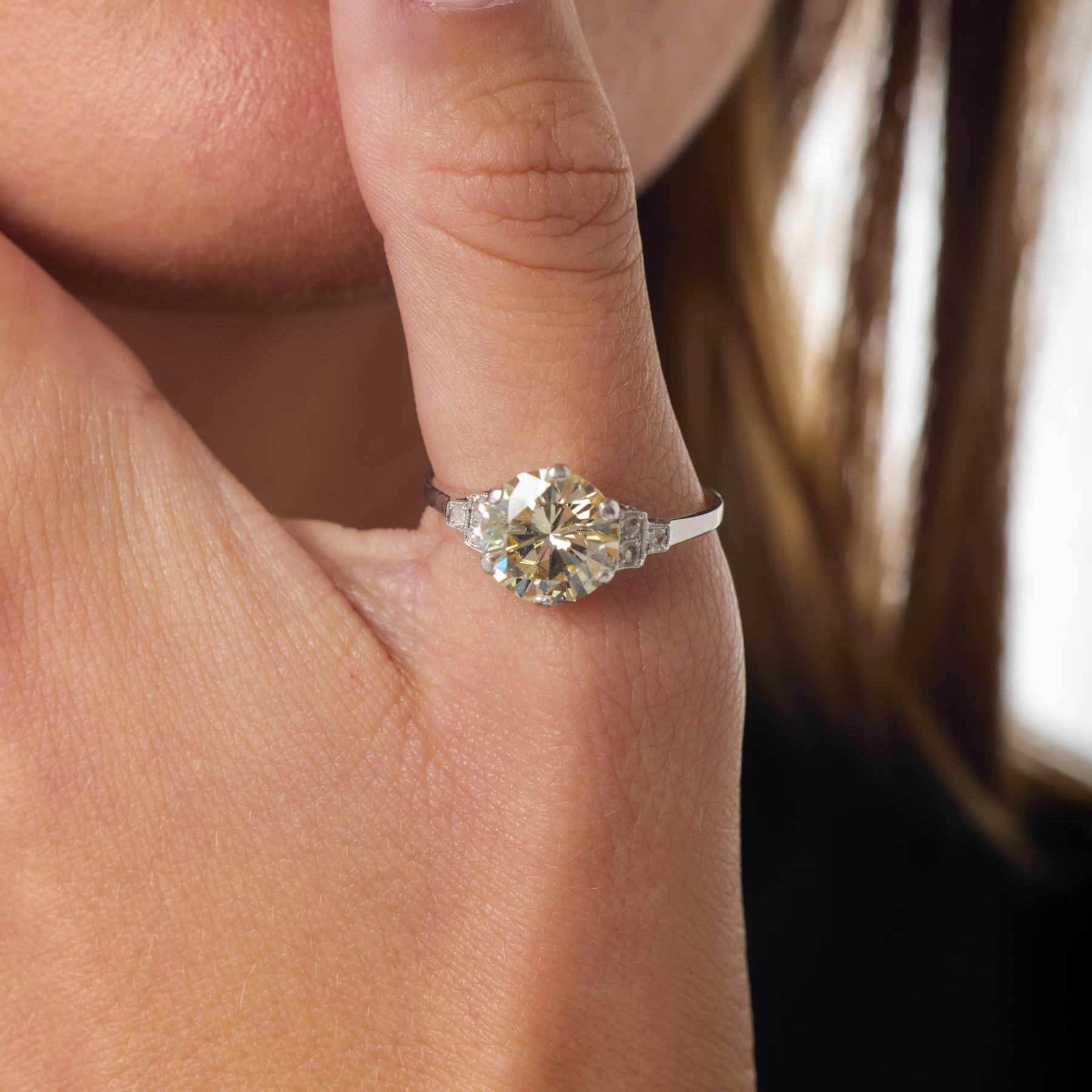 Este llamativo anillo de compromiso Mid Century centra un audaz diamante brillante redondo de 3,04 quilates, cuya cálida tonalidad y vivo fuego interior crean una presencia singularmente hipnotizadora. El engaste de platino eleva la piedra con