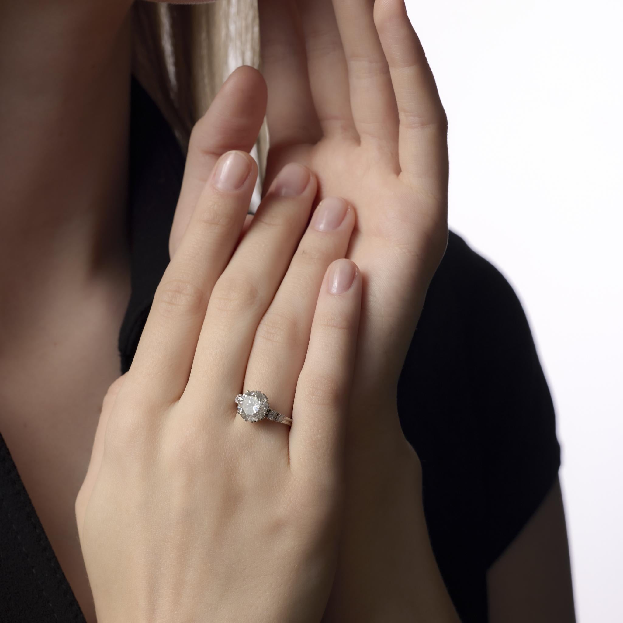 Cette bague en platine du milieu du siècle met en valeur un diamant GIA de 3,32 carats flanqué de pierres d'accent brillantes, capturant une sophistication raffinée et un charme vintage durable.