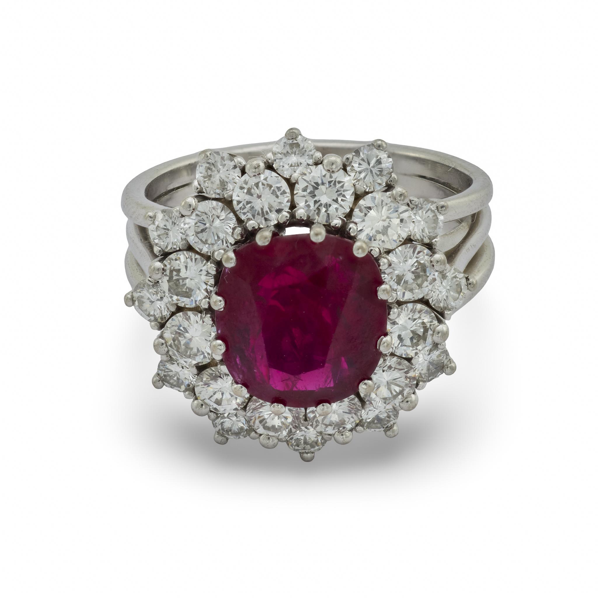 Un magnifico esempio di glamour di metà secolo, questo squisito anello a grappolo è incentrato su un raro rubino tailandese senza calore che risplende di un colore naturale e non esaltato. La gemma da 3,50 carati con taglio a cuscino irradia una