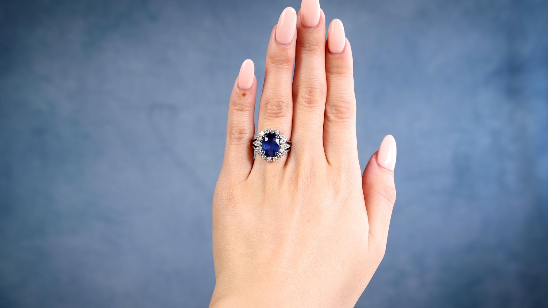 One Mid-Century GIA 3.94 Carat Ceylon Sapphire Diamond Platinum Ring. Featuring one GIA oval mixed cut sapphire of 3.94 carats, accompanied by GIA #2231196557 stating the sapphire is of Ceylon (Sri Lanka) origin. Accented by ten round brilliant and