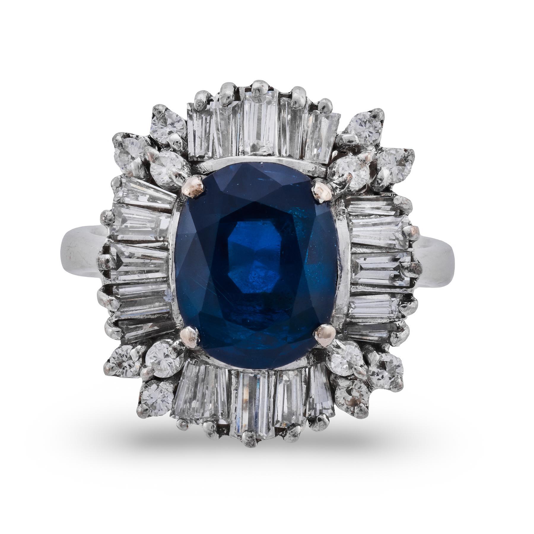 Radieuse et raffinée, cette bague en platine du milieu du siècle met en valeur un magnifique saphir birman de 4,00 carats, certifié par la GIA, d'un bleu royal éclatant et d'une pureté naturelle, non chauffée. La pierre centrale de taille coussin