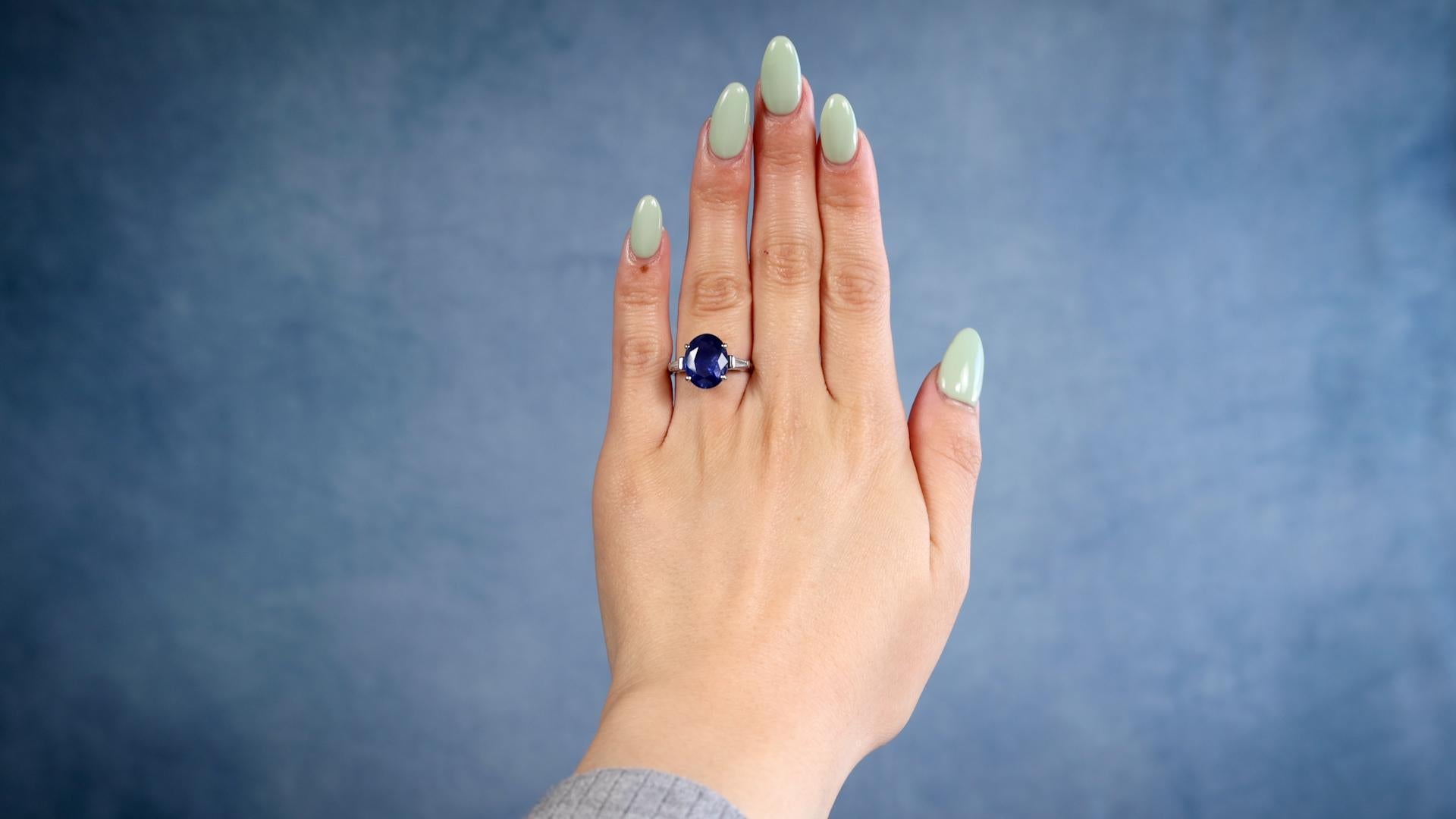 One Mid-Century GIA 4.58 Carat Ceylon Sapphire Diamond Platinum Ring. Featuring one oval mixed cut sapphire of 4.58 carats, accompanied by GIA #2235197742 stating the sapphire is of Ceylon (Sri Lanka) origin. Accented by two tapered baguette cut