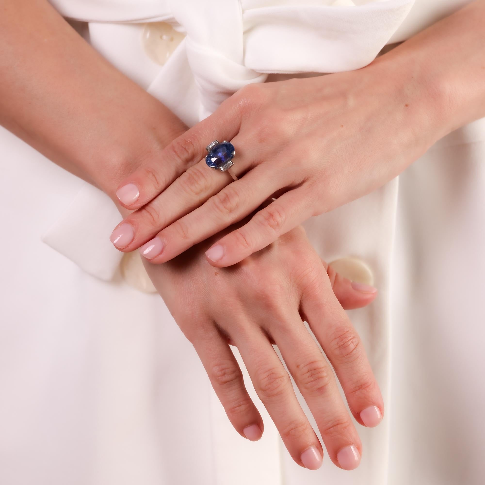 This exquisite Mid-Century ring showcases a striking 9.80-carat Sri Lankan sapphire, flanked by sparkling baguette diamonds in a timeless platinum setting.

Certificate: GIA #2231440206
Center stone: Oval cut blue sapphire 
Weight: 9.80