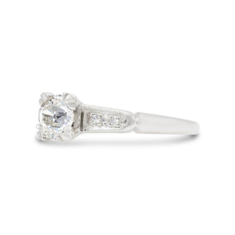 A charming old European cut diamond centers this mid-century engagement ring. Accented by two bead-set single cut diamond shoulders bordered by a delicate milgrain, this darling platinum band is a perfect under 1 carat engagement ring option.
 