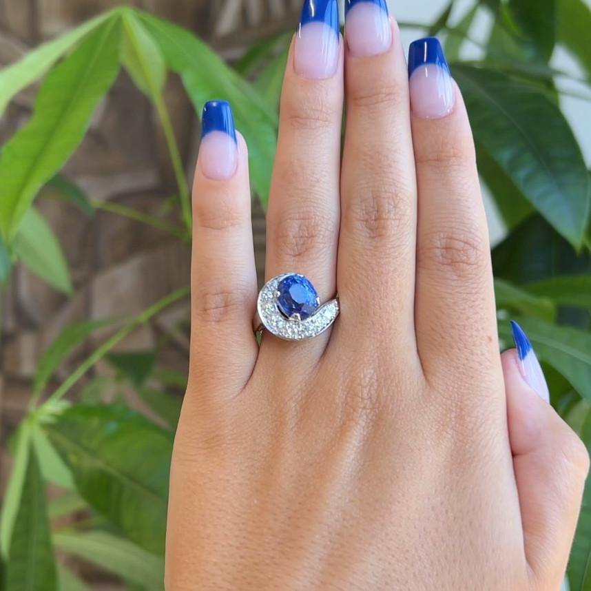 One Mid Century GIA No Heat Ceylon Sapphire Diamond Platinum Swirl Ring. Featuring One GIA oval mixed cut blue sapphire of approximately 5.00 carats, accompanied with certificate #2225505376 stating the sapphire is of Sri Lanka (Ceylon) origin and