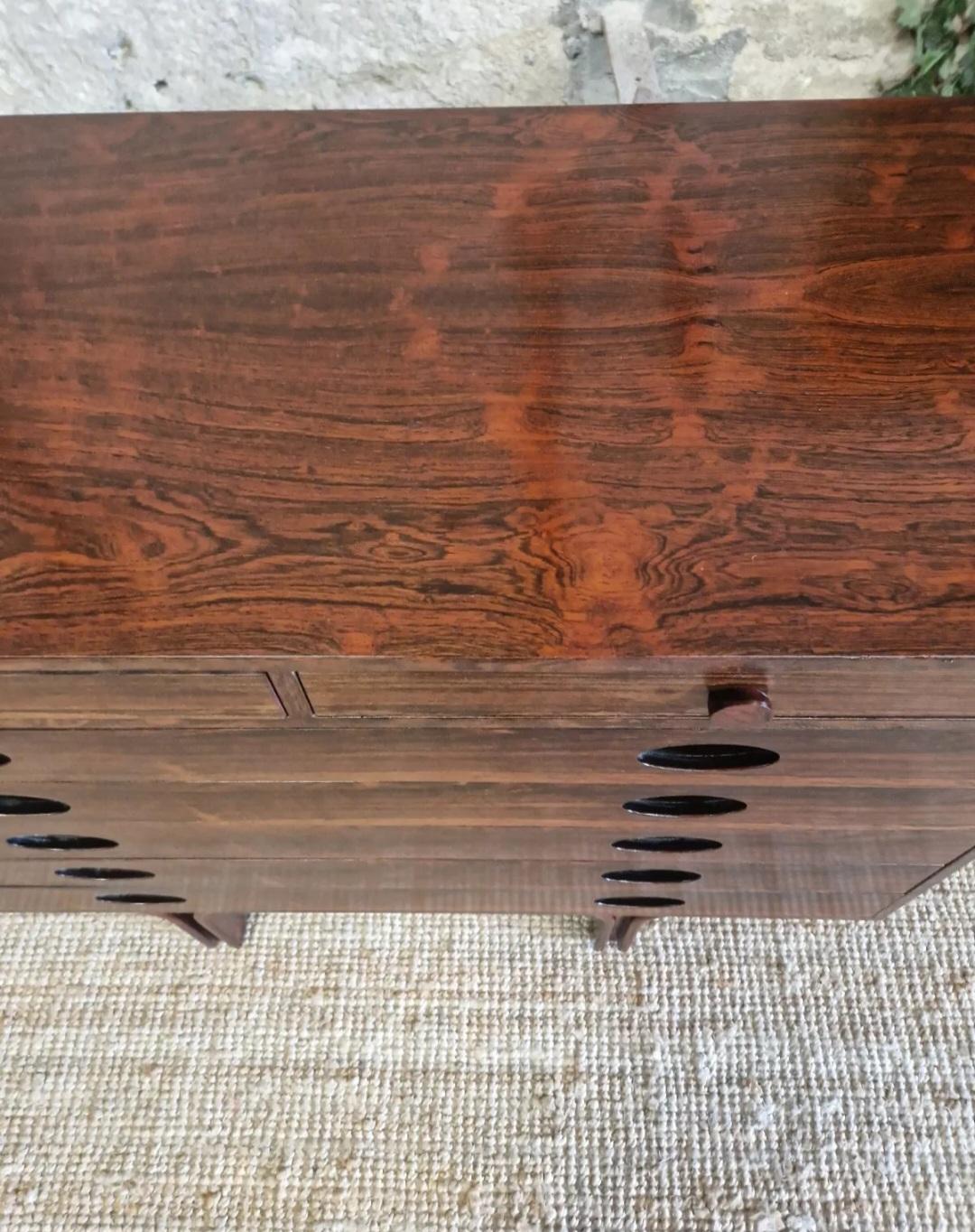 This stunning Mid Century chest of drawers by Gianfranco Frattini is a true statement piece for any room. It has a beautiful Rosewood veneer finish and smooth features, with cup handles that add a touch of mid-century modern style. The seven