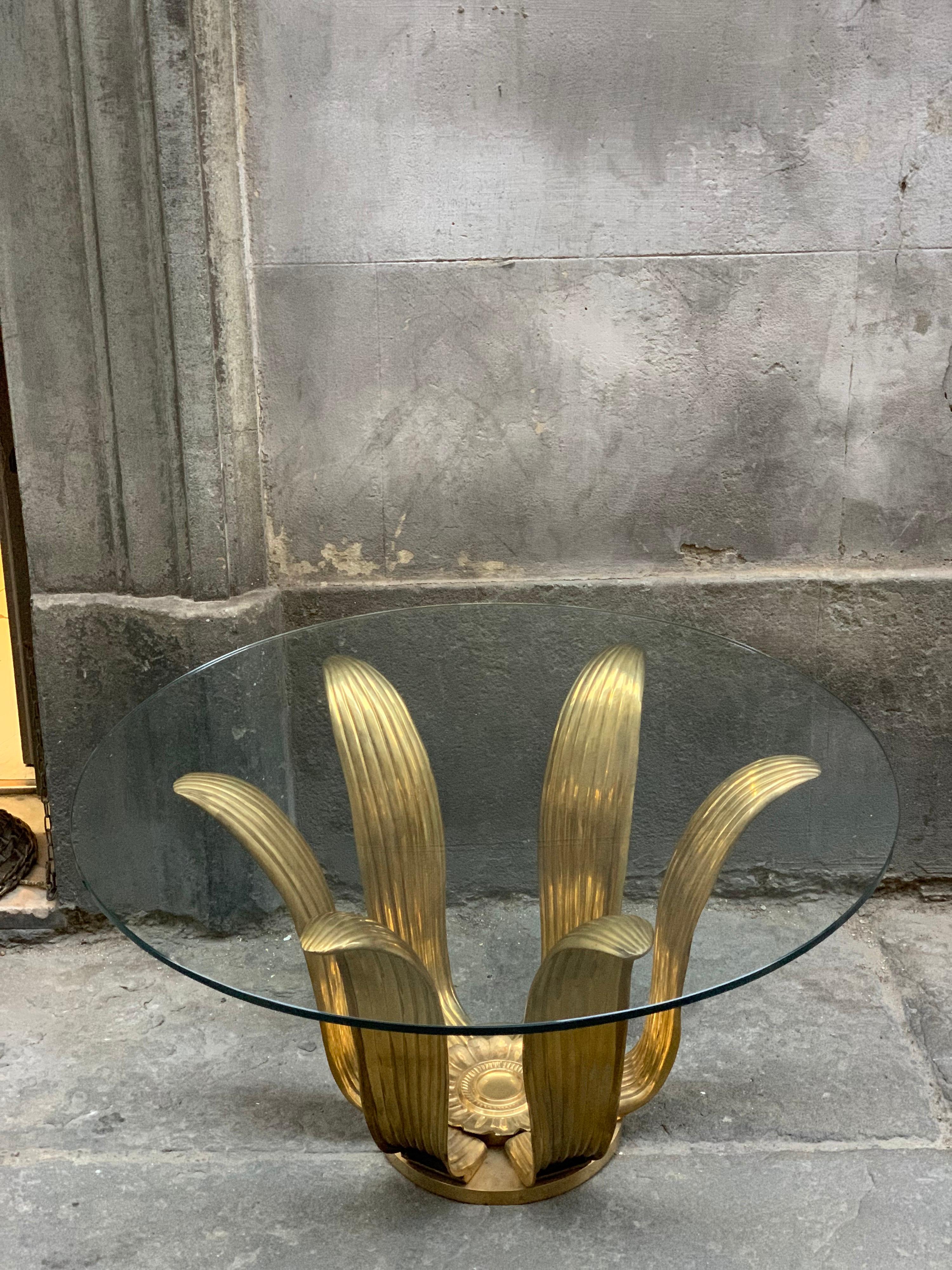 Mid-century gilt bronze flower coffee table with round glass top.
The gilt bronze wonderful patinated has its original finishing and it presents signs of use and age that increase its taste. The structure is solid and heavy.