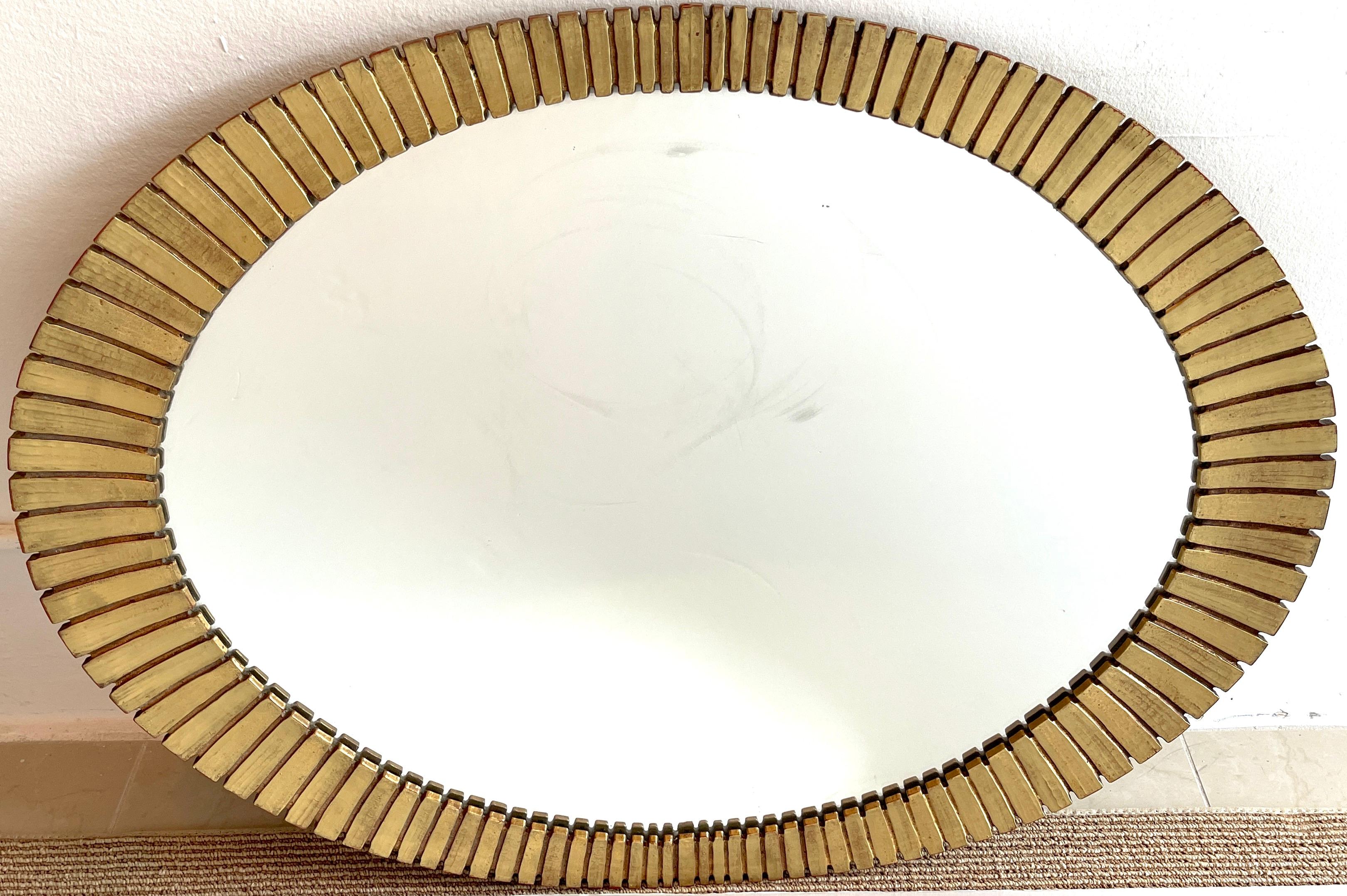 Mid Century Gilt Lacquer 'Eyelash' Segmented Mirror, Oval lacquered resin mirror, beautiful patina with some red bole showing. The inset mirror measures 30