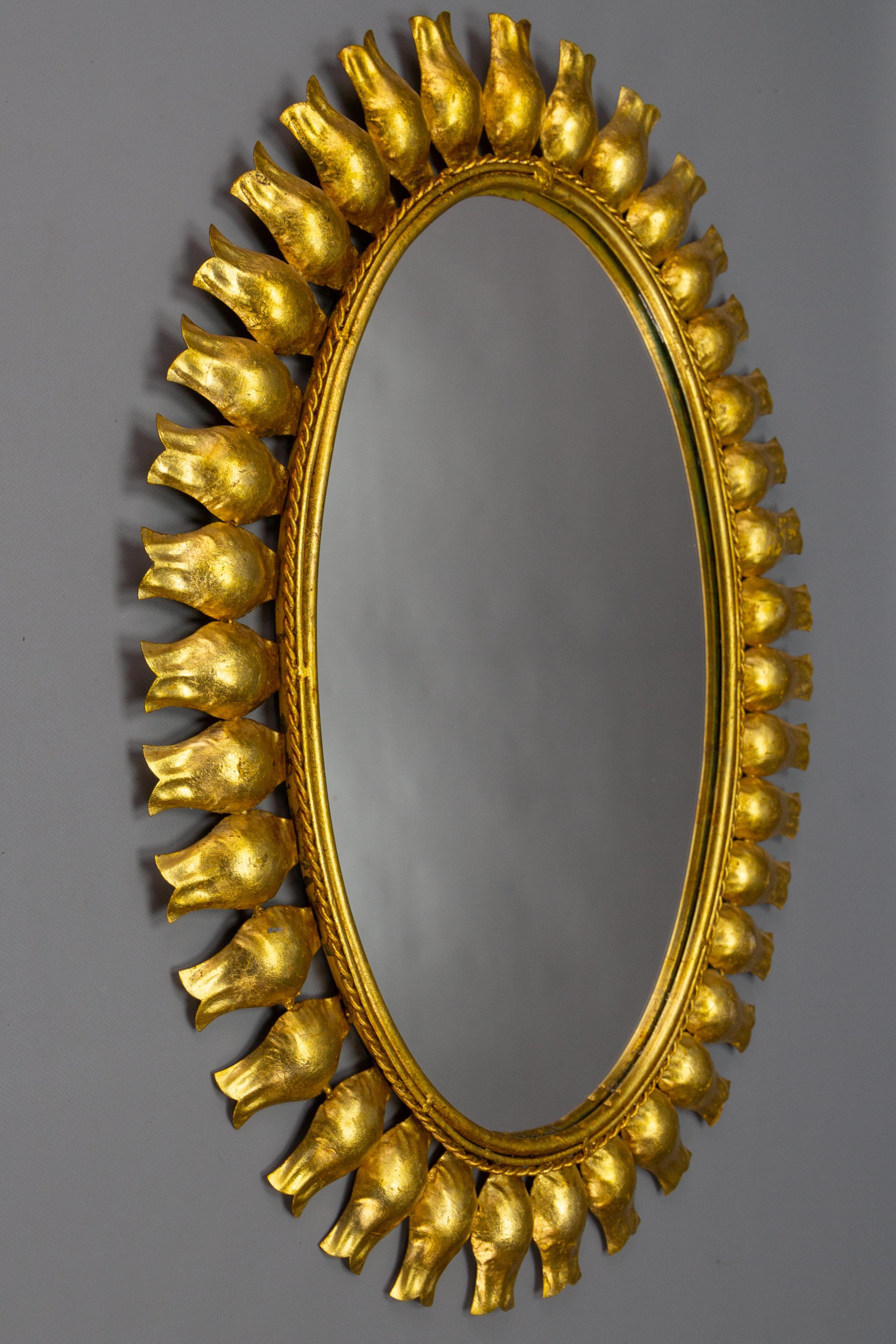 Sonnenschliffspiegel aus vergoldetem Metall aus der Mitte des Jahrhunderts, Deutschland, ca. 1950.
Ein schöner ovaler Spiegel im Hollywood-Regency-Stil in Form einer Sonne oder eines Sonnenschlages mit einem vergoldeten Metallrahmen mit