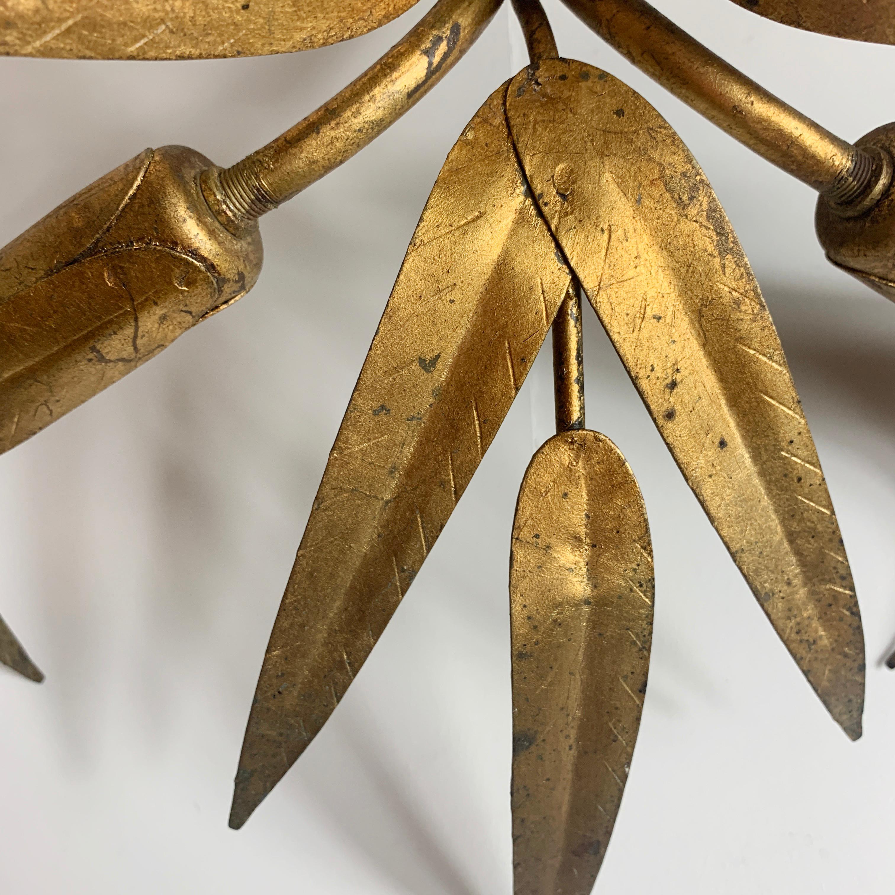 Midcentury Gilt Spanish ceiling light
Attributed to Ferro Art, Spain
Beautiful gilt leaves surrounding spikey gilt buds
There are 3 bulb holders one in each bud
A small ceiling rose has a hook on the back to attach
Measures: 43 cm width, 24 cm