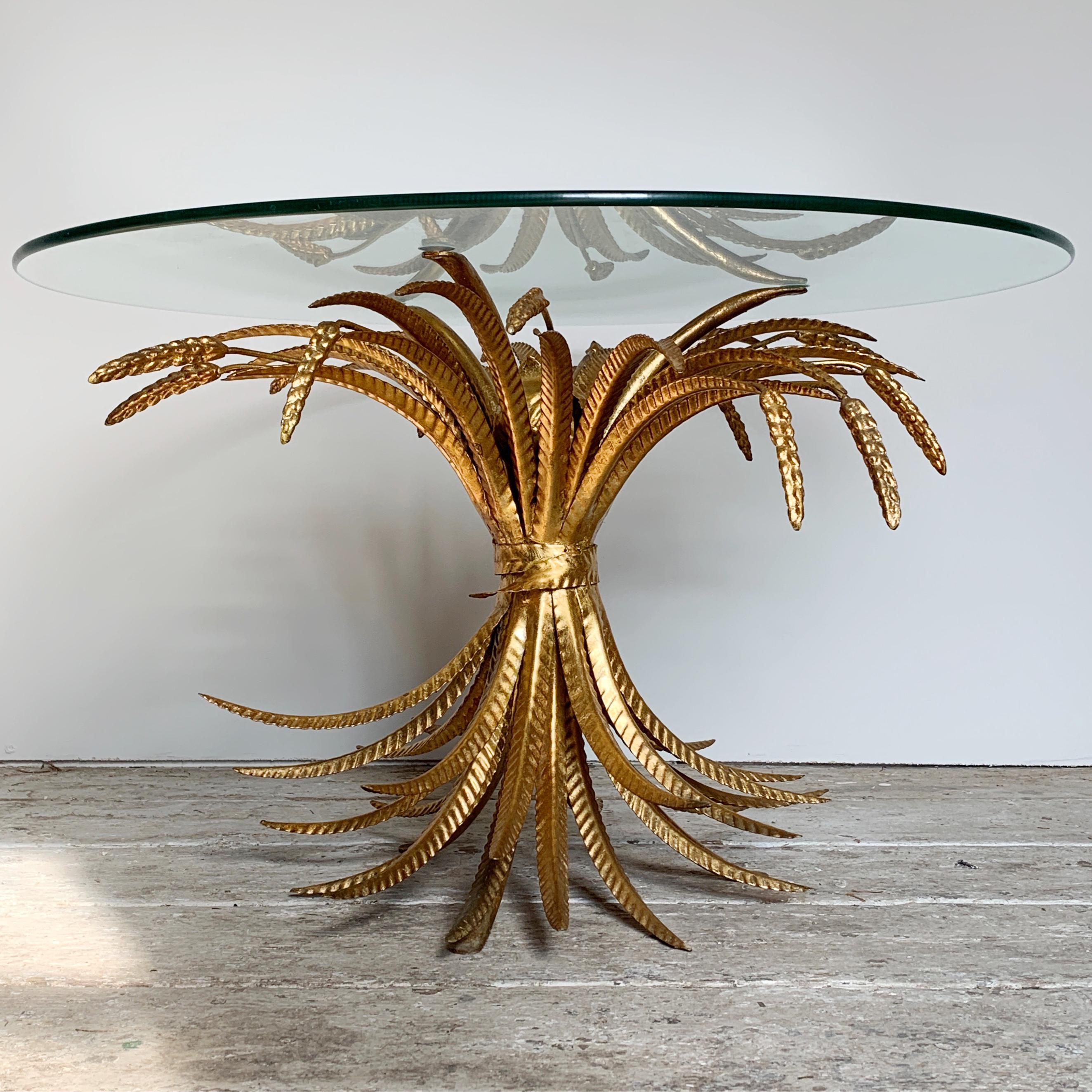 Mid Century gilt wheat sheaf table
circa 1960s-1970s, French
Fantastic glass topped coffee table with gilt metal base depicting a bundle of wheat sheaf and leaves
The table is bright gilt with a crimped design detail to the leaves
The glass top is