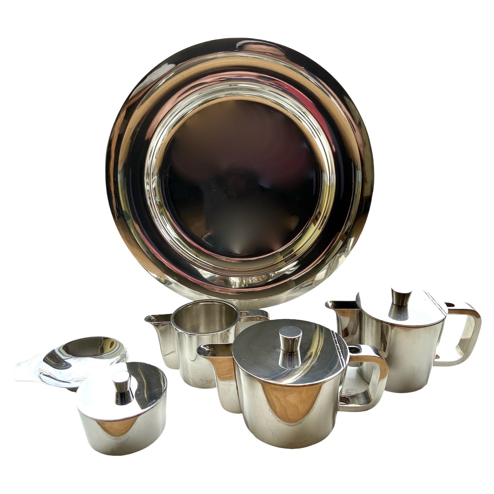 A Gio Ponti 6 piece mid-century silver plated coffee and tea set on a small circular tray. Designed for the VI triennale, 1930's to 1950's.
comprising 6 items
a 50CL tea pot, (seems unused).
a 35CL coffee pot, (seems unused).
a 25CL cold milk/water