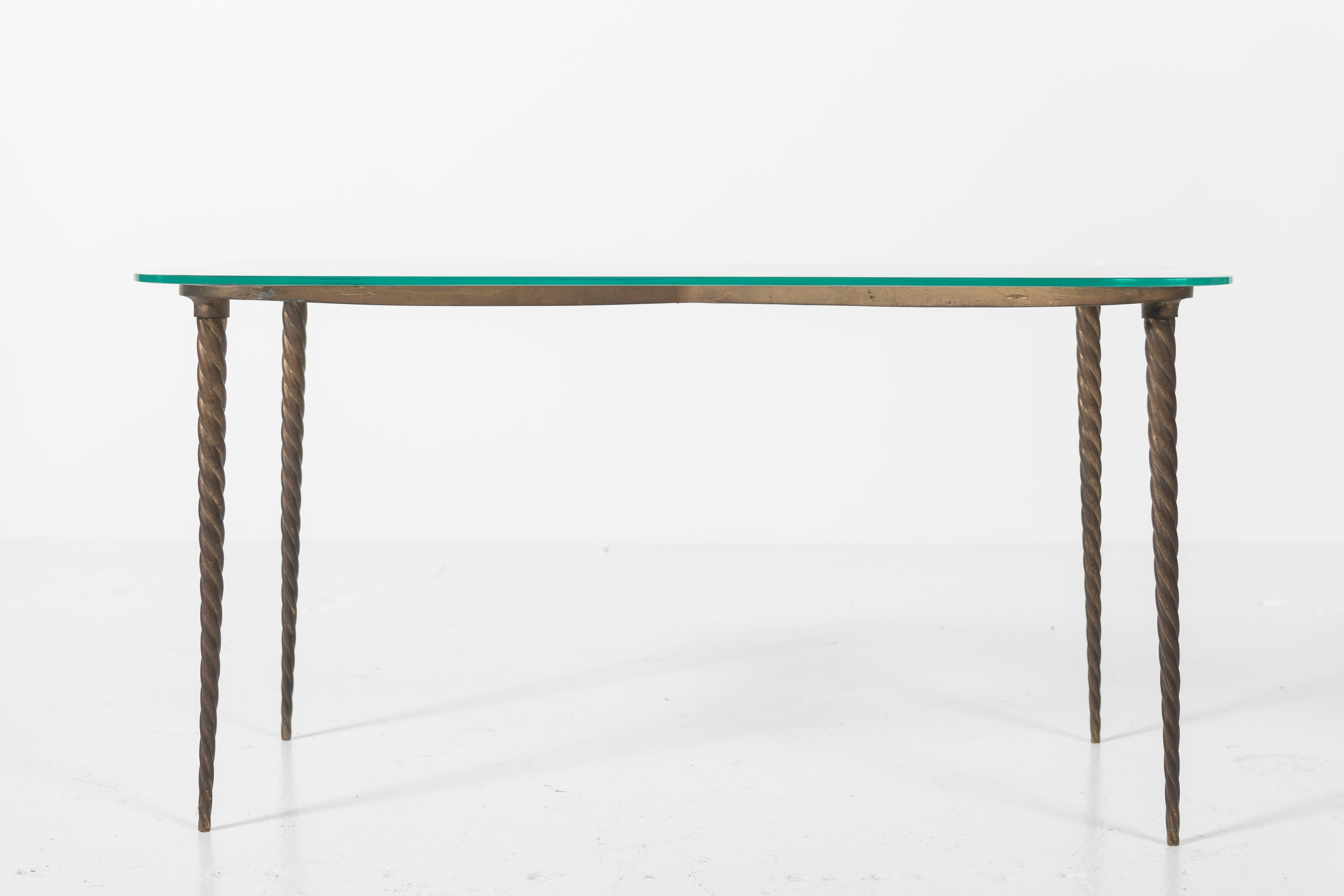 Beautiful ground glass and cast brass coffee table of Italian mid-century design. The design features a stylized clover shaped base of patinated/cast brass, with braided legs and a glass tabletop with rounded edges.
 