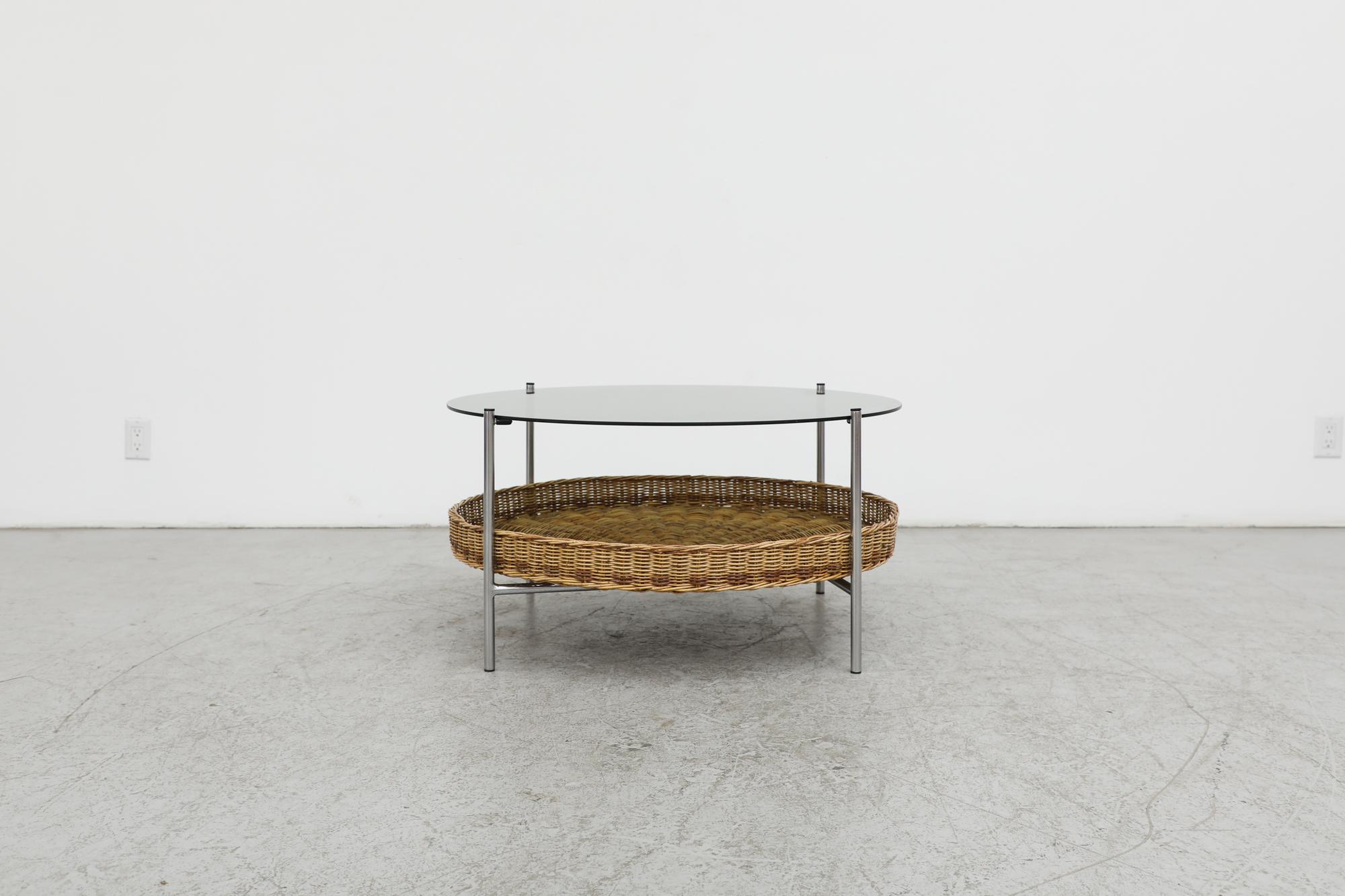 Low, mid-century side table by Dirk van Sliedregt for the Gebr. Jonkers furniture manufacturing company. The design features a round, smoked glass top and four matte chrome legs. The legs are crosswise connected by two steel tubes, on which a round