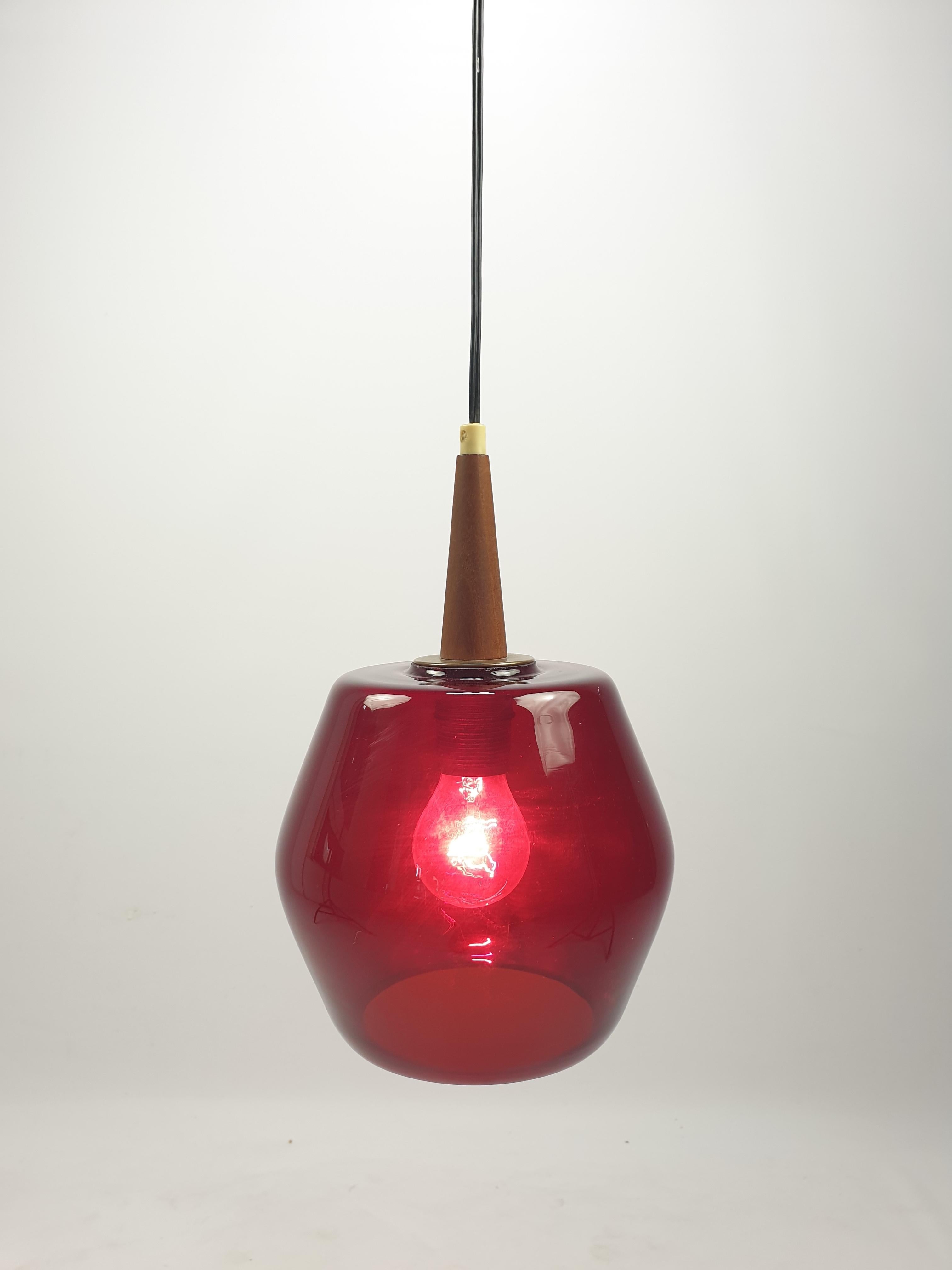Very nice pendant fabricated in The Netherlands in the 70's.

Beautiful red colored glass lampshade with a teak holder.

Very good vintage condition, no cracks or chips. 
The wiring is suitable for all countries around the world. 