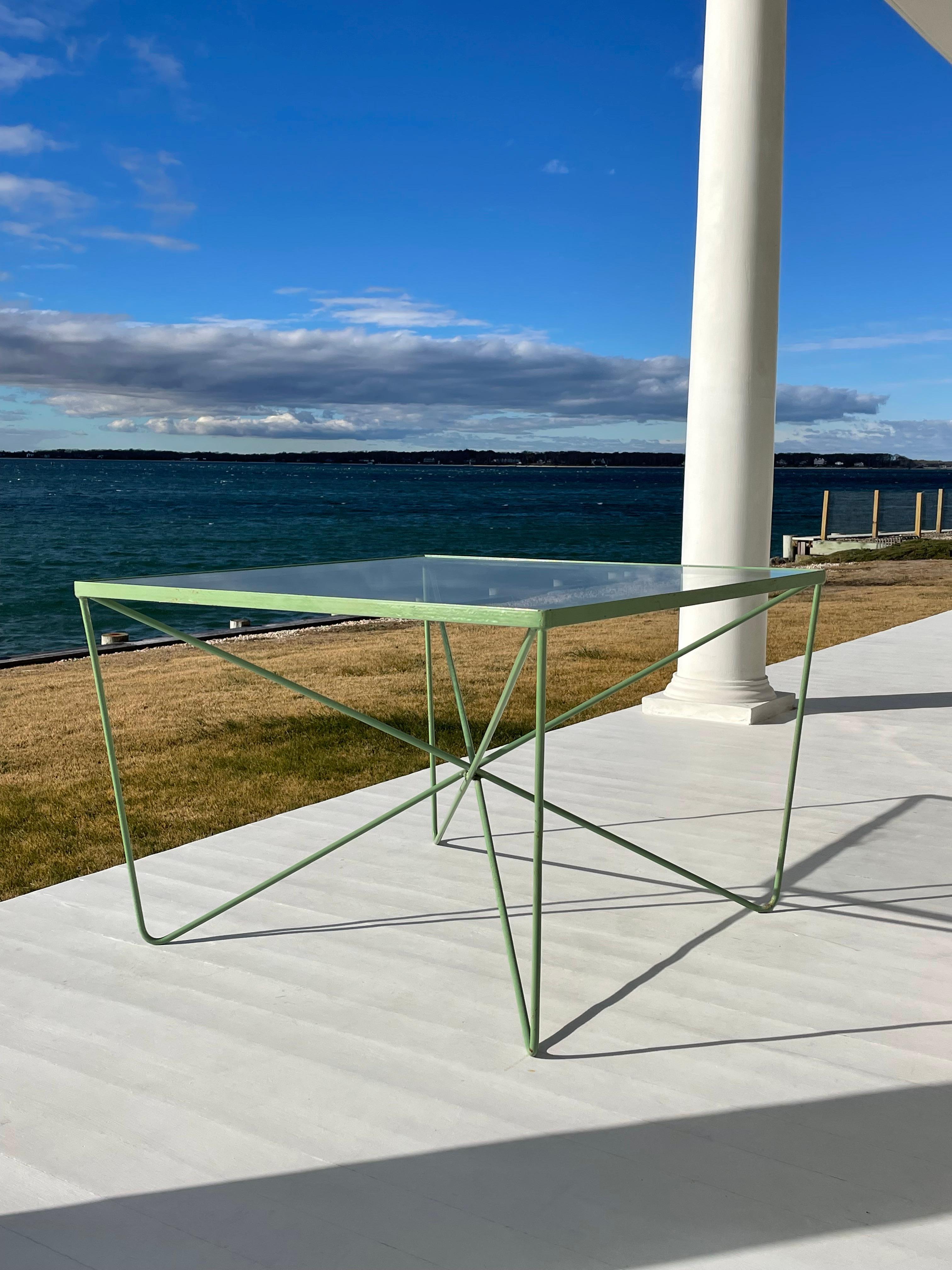 Beautiful bent and welded metal modern industrial design coffee table in a green powder coat, with a clear glass top . Circa 1950s. Some call it a butterfly table, comparing to the iconic butterfly chairs . Minimalist design by Luther Conover.