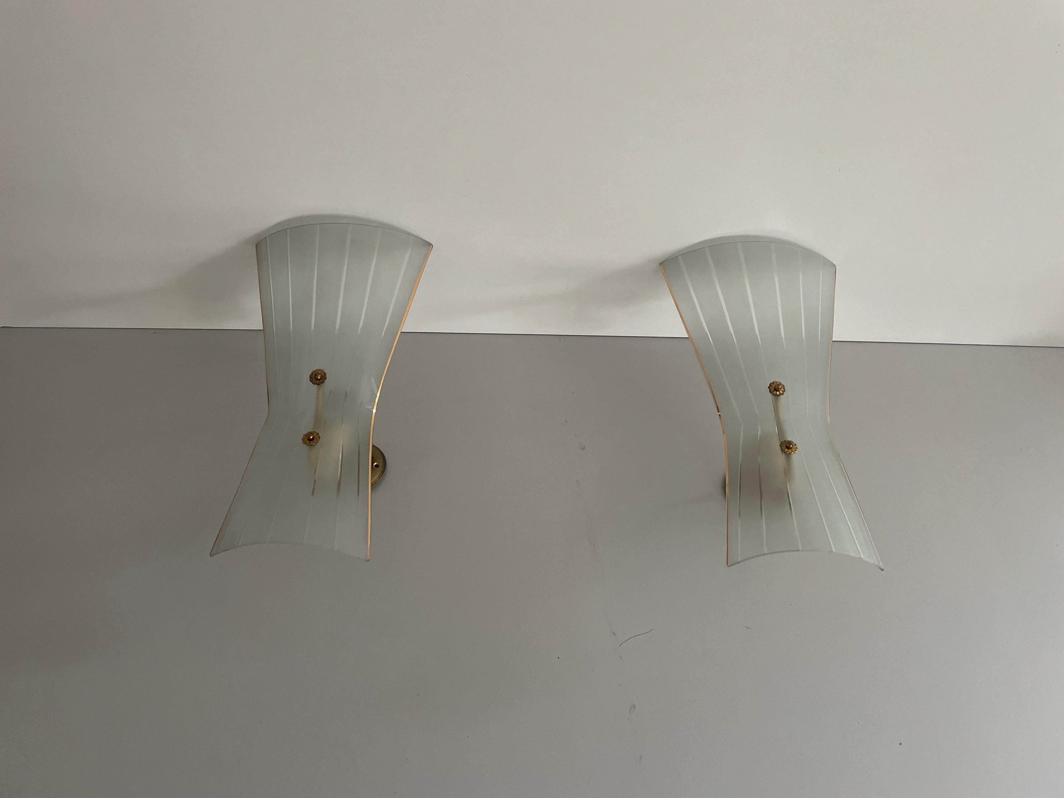 Pareja de candelabros de cristal y latón de mediados de siglo, años 50, Italia

Apliques muy elegantes y minimalistas
La lámpara está en muy buen estado.

Estas lámparas funcionan con bombillas estándar E14. 
Con cable y apto para su uso en todos