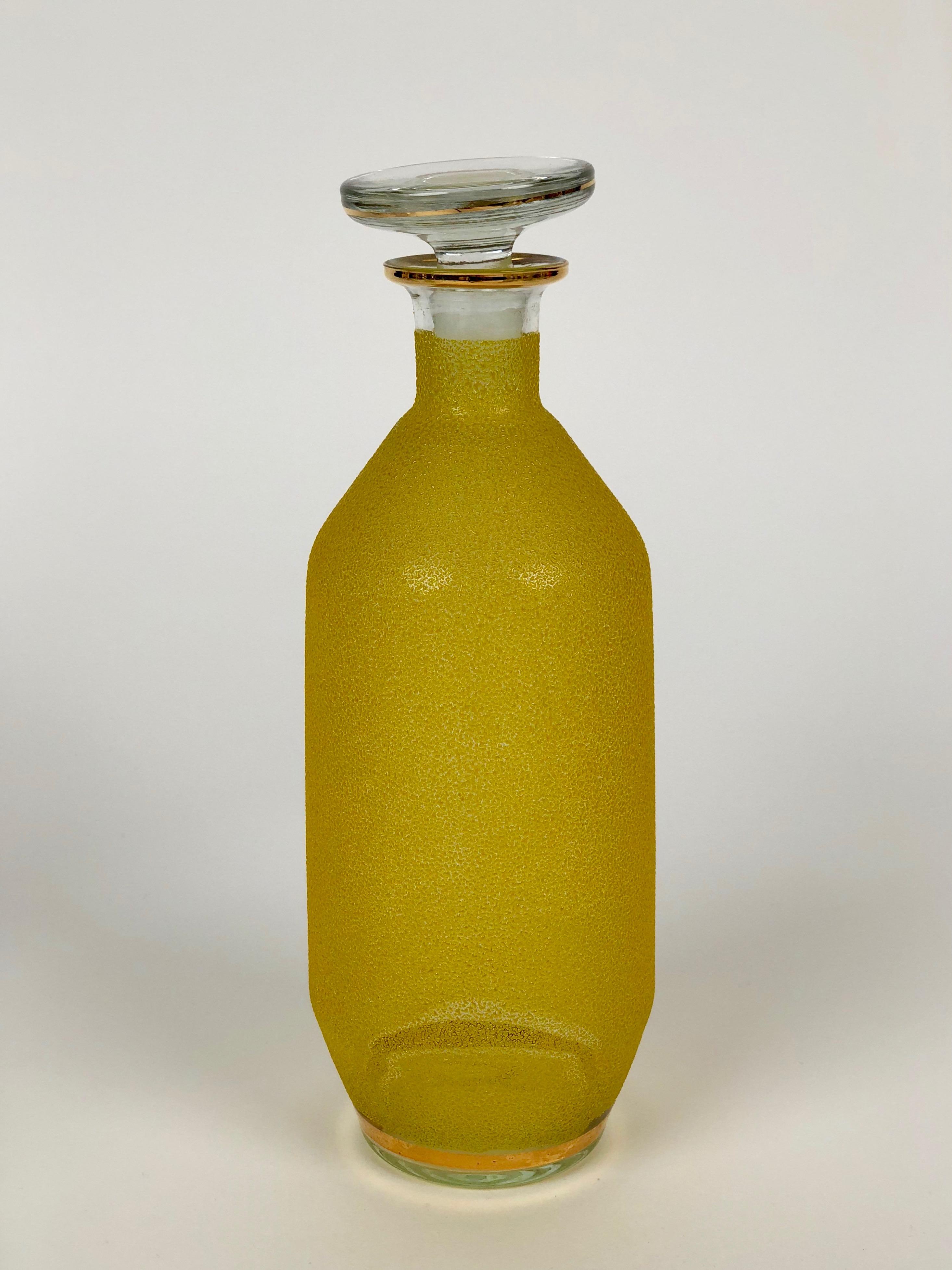 Glaskaraffe aus der Jahrhundertmitte mit gelbem Glasdekor und goldenen Streifen.
Die Farbe besteht aus farbigen Glaspartikeln, die an einem Glaskörper befestigt sind.

Sie können es für Likör oder als kreative Alternative für Öle verwenden
und