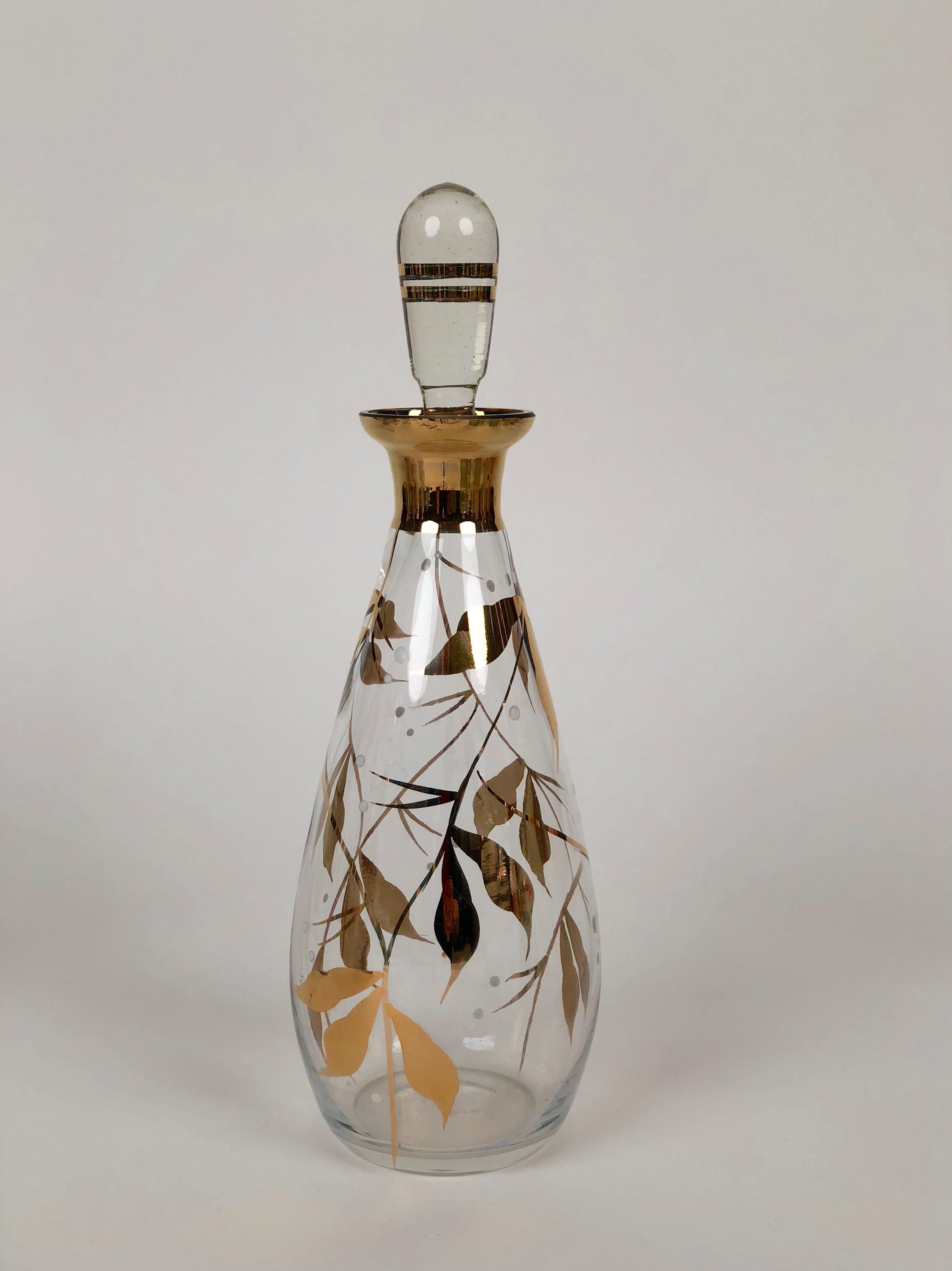 Glass carafe with hand painted floral pattern in gold and white.
Made in Czechoslovakia.

You can use them for liquor  or as a creative alternative  for oils
and vinegars .