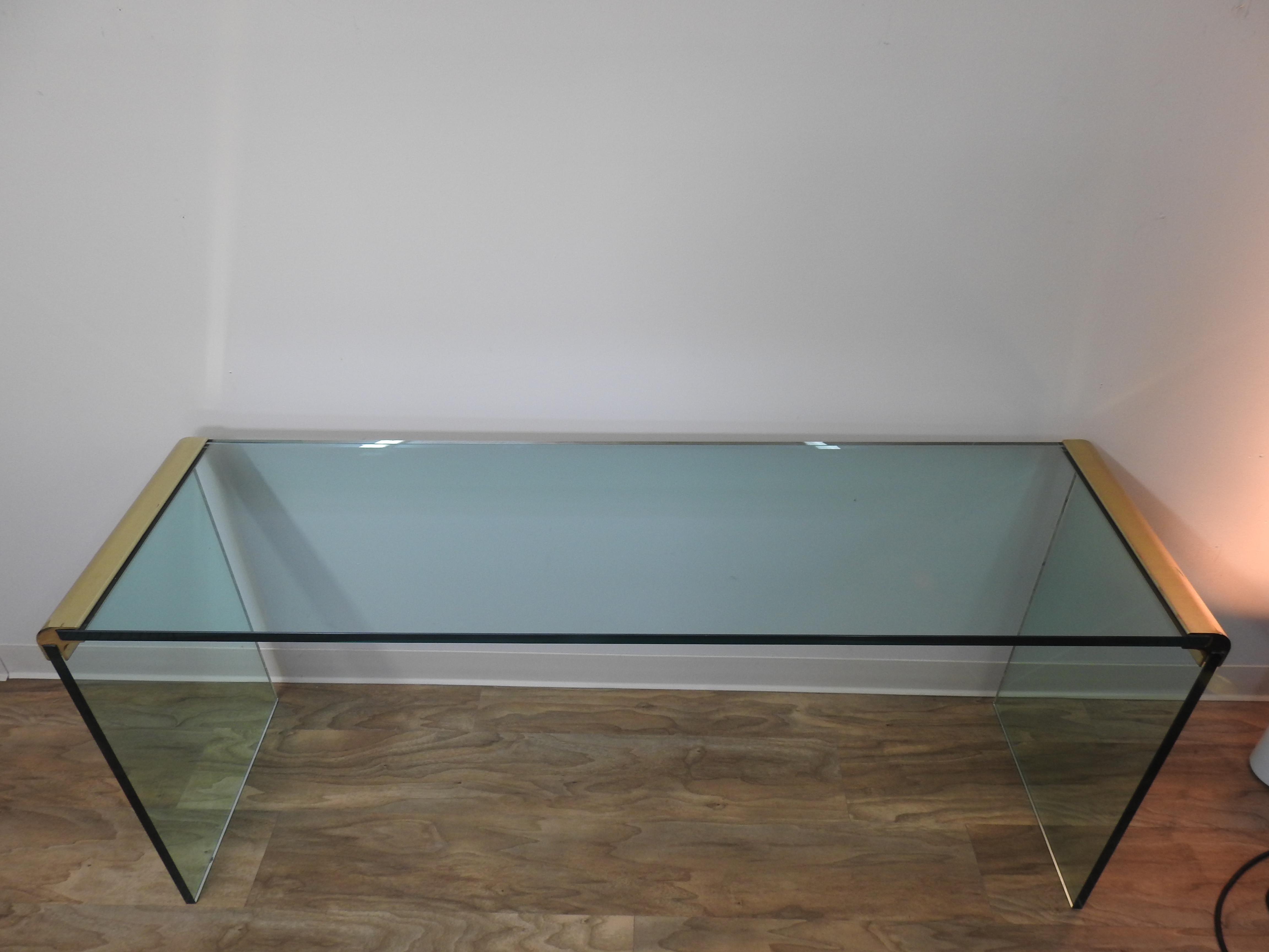 Simply beautiful midcentury glass and brass sofa table. The glass is 1/2 inch thick and makes for a gorgeous sofa table with rounded edges done in brass. Impeccable with no scratches in the glass.