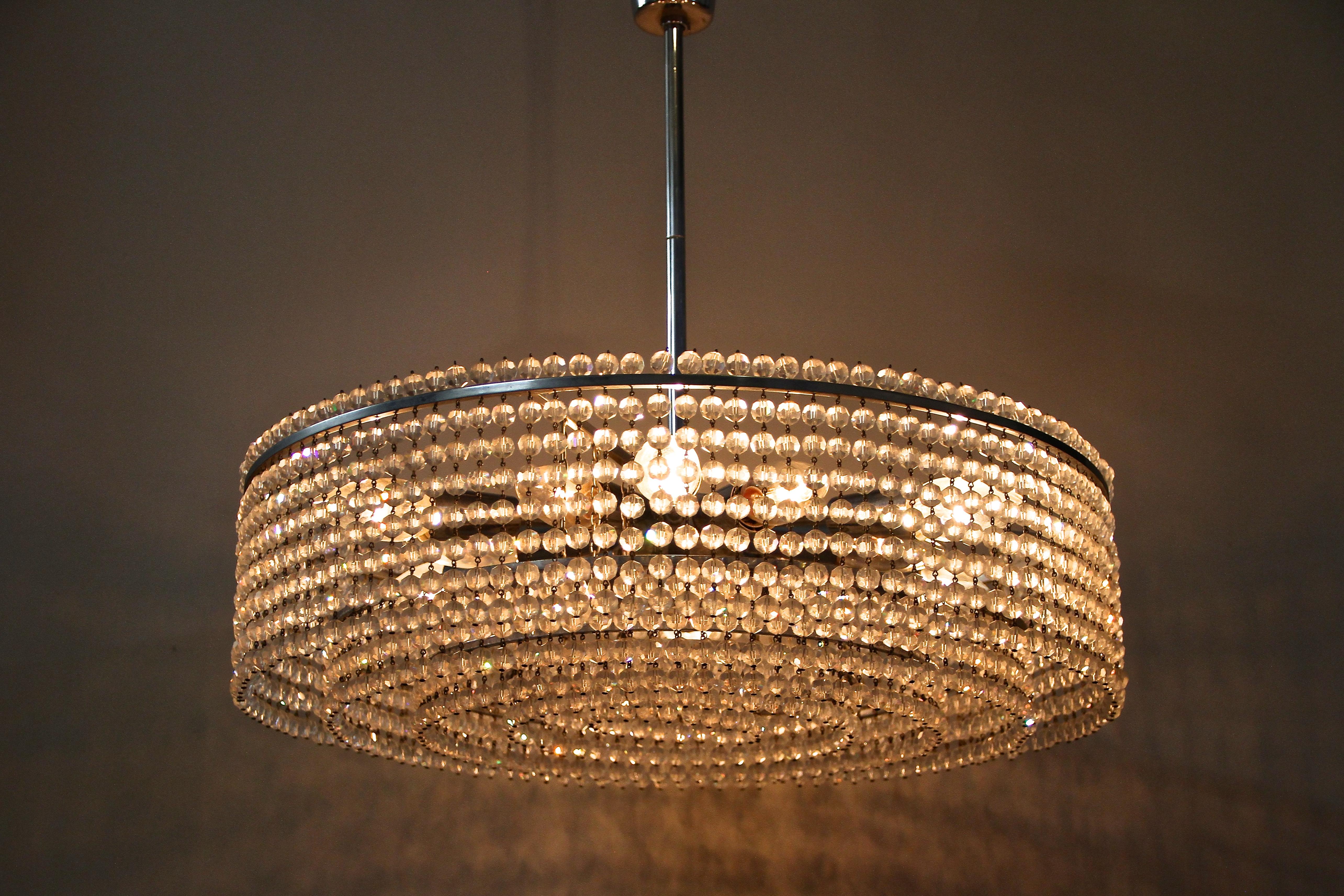 Fabulous Mid-Century glass chandelier made in Austria, around 1960. A timeless lightning piece with an amazing design built of hundreds of small cut glass pearls mounted on five rings in different heights. This very elaborate construction in