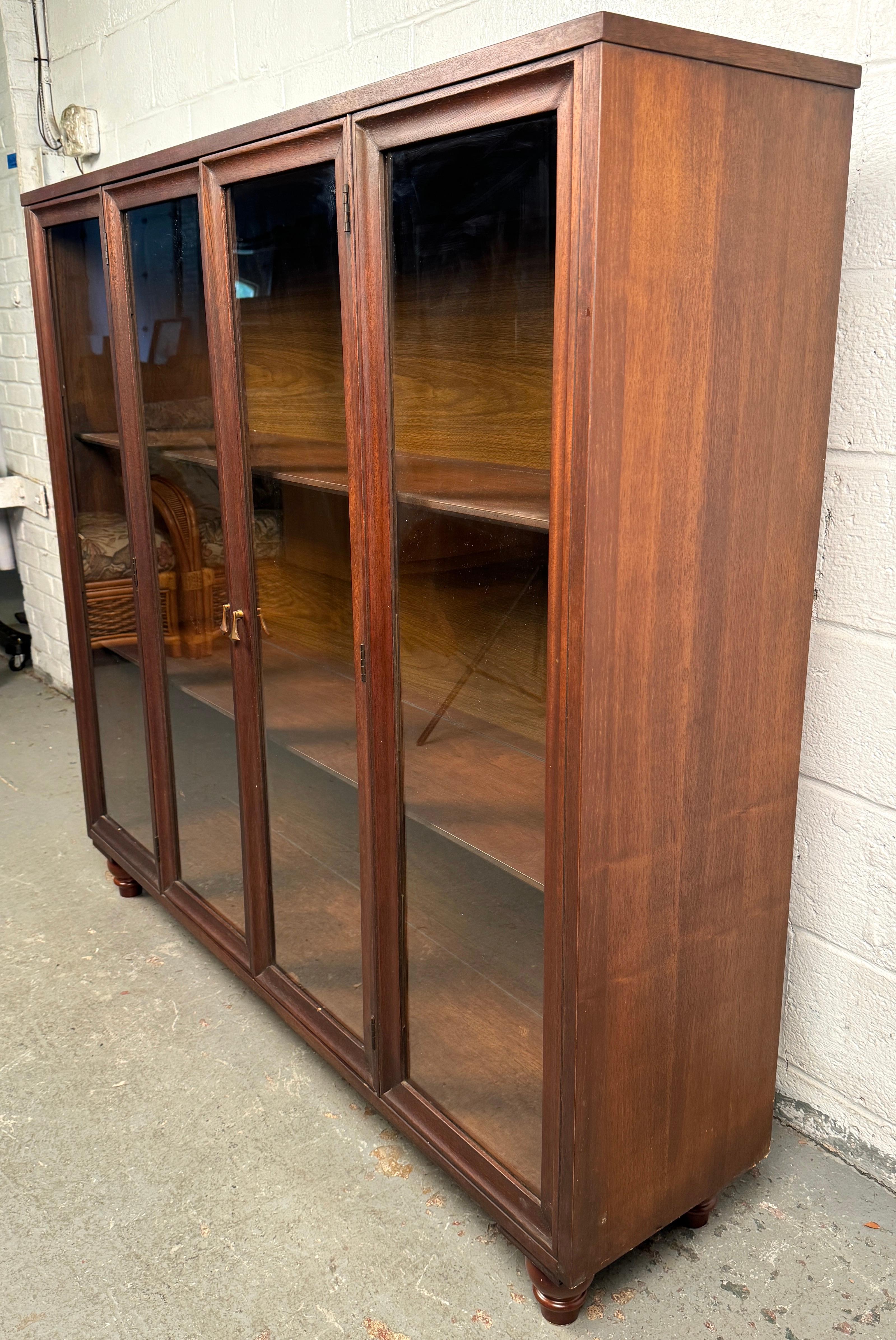 Eleva il tuo spazio con questo mobile vintage in legno e vetro splendidamente conservato, un mix perfetto di funzionalità e stile. Caratterizzato da una calda finitura in legno e da ante rivestite in vetro trasparente, questo mobile offre sia