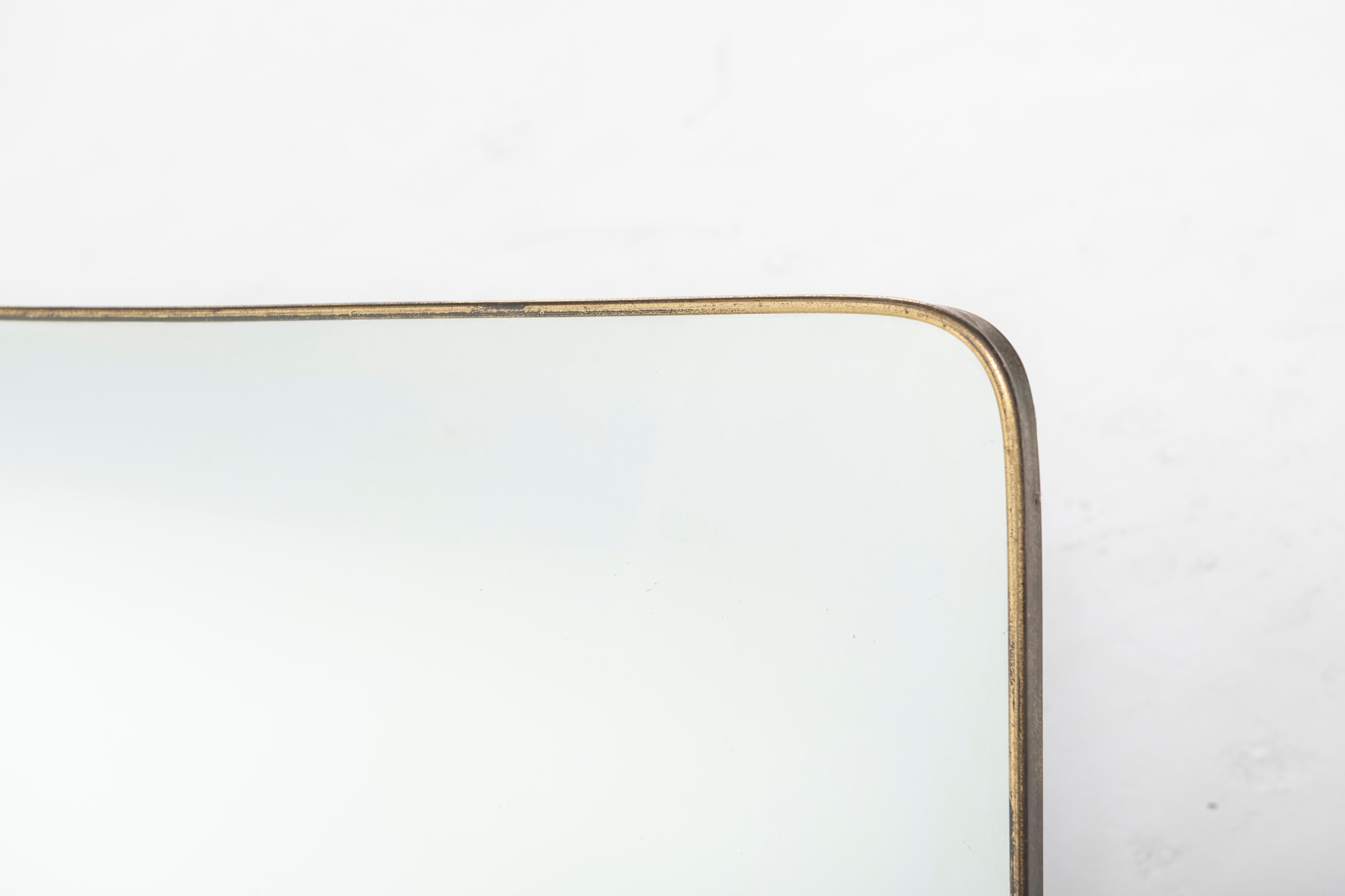 Classic Italian mirror can be hung both horizontally and vertically. Mirror is framed in brass with rounded edges. 