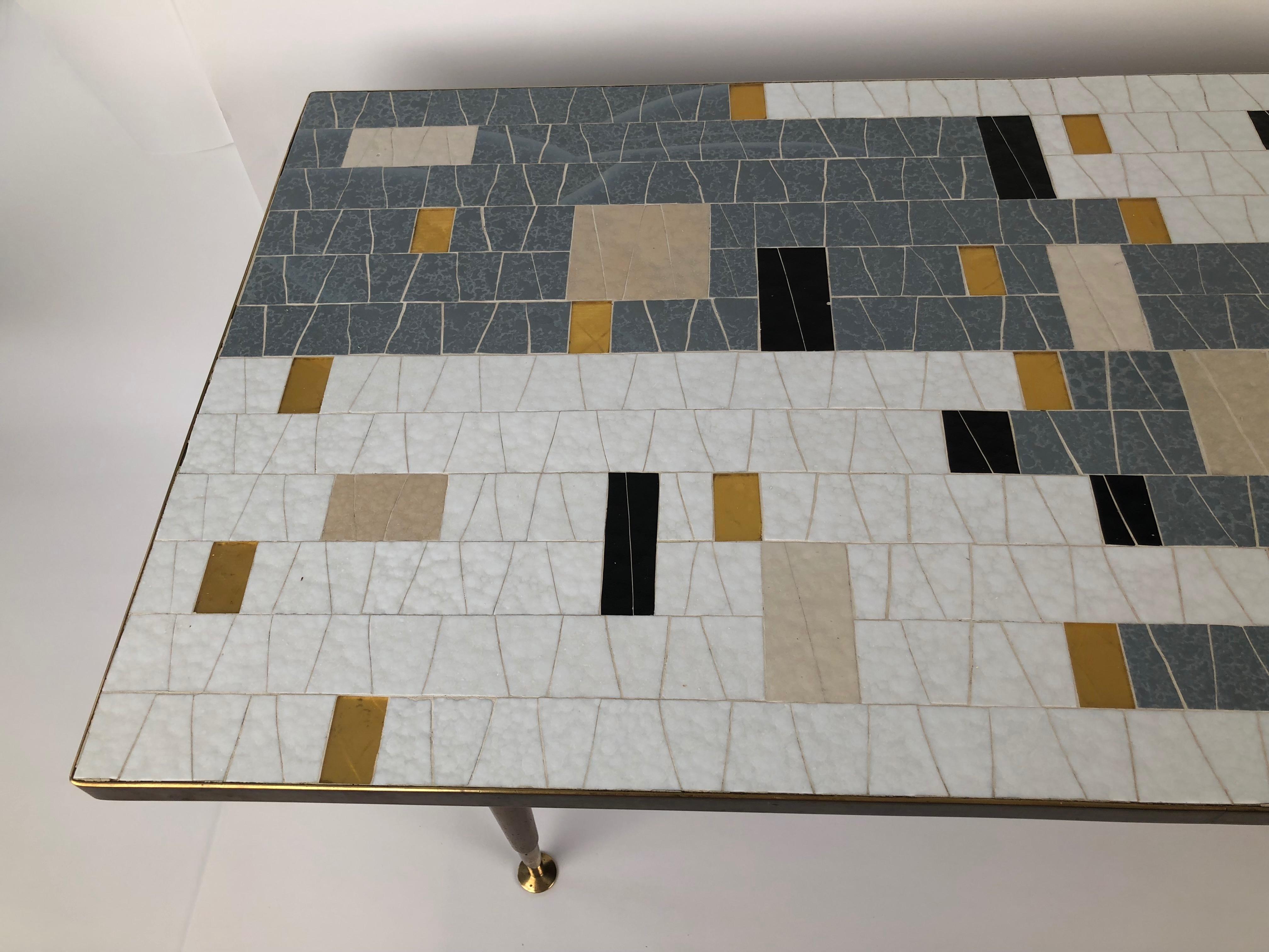 Une belle table basse en mosaïque de verre du milieu du siècle dernier de Ilse Möbel, Danemark. Cette remarquable mosaïque de verre est en très bon état.
Le jeu entre les couleurs unies et transparentes renforce le motif abstrait, qui devient une