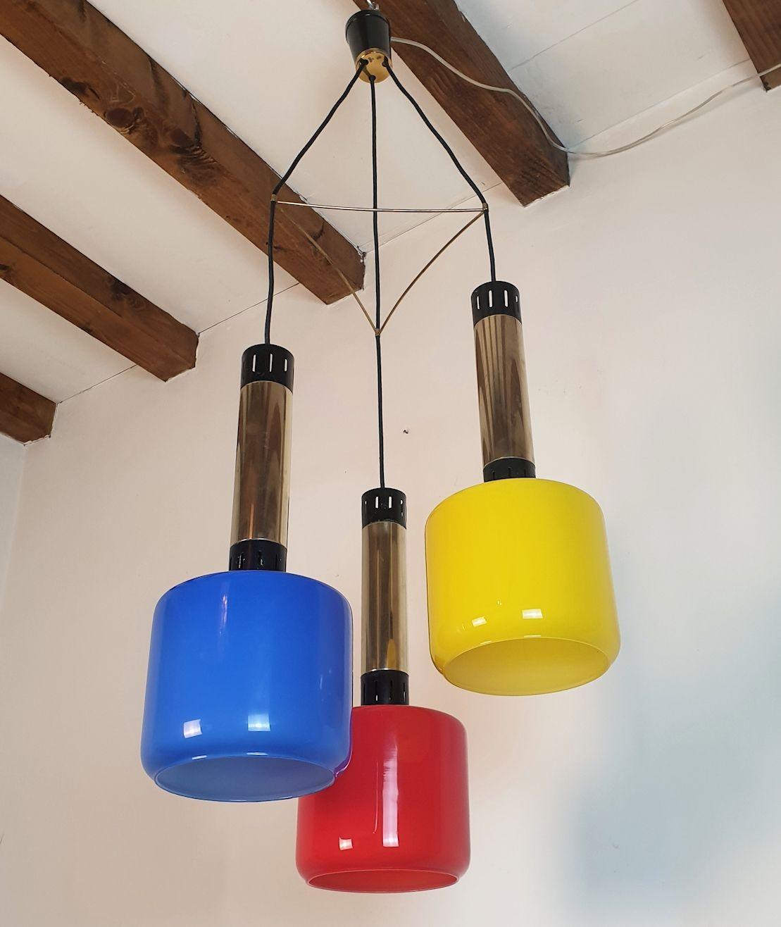 Lampadario a sospensione in vetro e ottone, di Stilnovo, Italia 1960.
Tre colori primari per questo originale lampadario vintage italiano.
Un famoso design Stilnovo della metà del secolo scorso, trendy e moderno.
Il lampadario vintage è composto da
