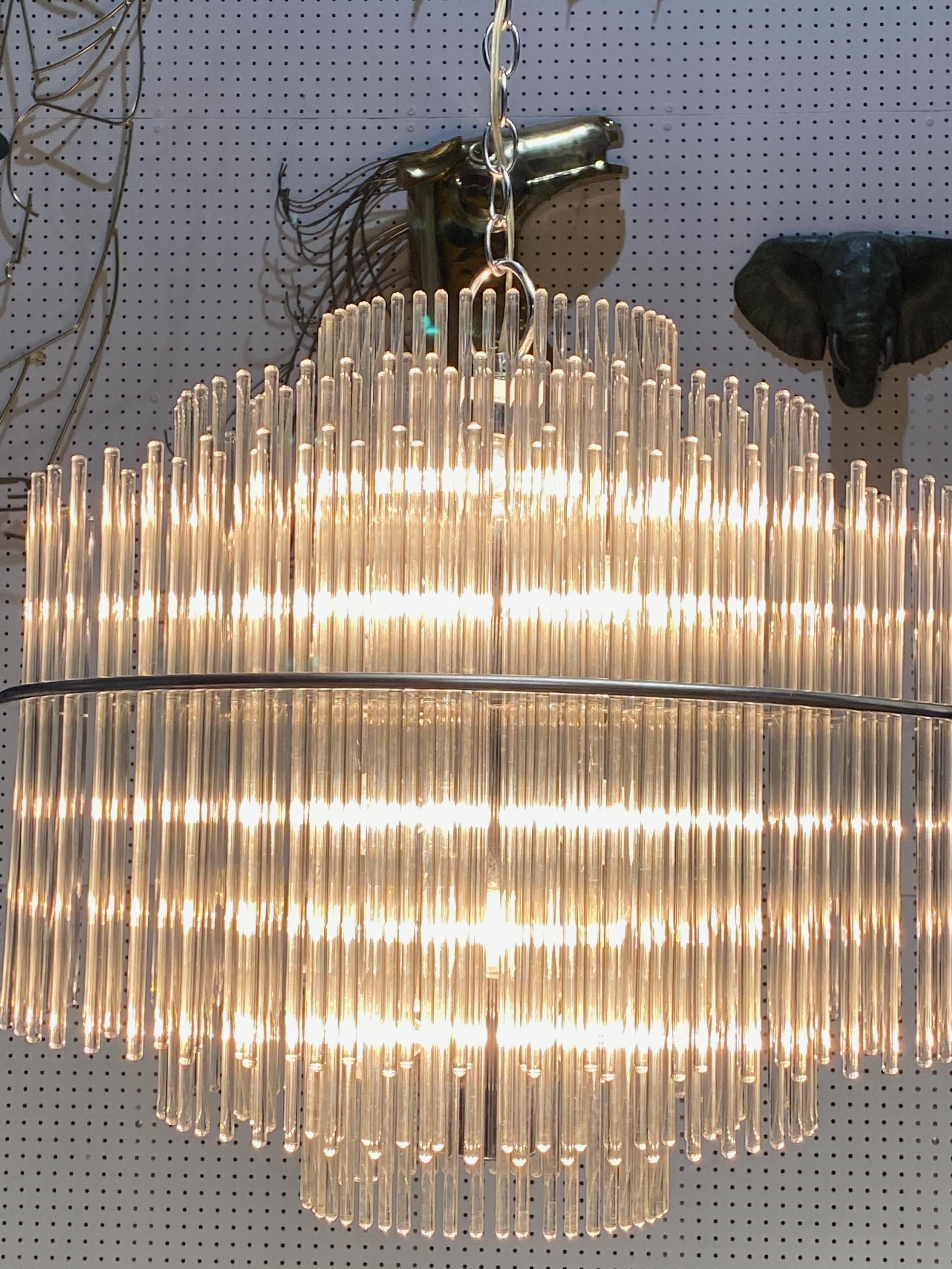 Midcentury glass rod two tier chandelier in the manor of Sciolari. Beautiful glass rods sit on a nickel frame giving off a cascading affect. Has been rewired for America use. 


Any amount of chain can be added for custom hanging length.
Height