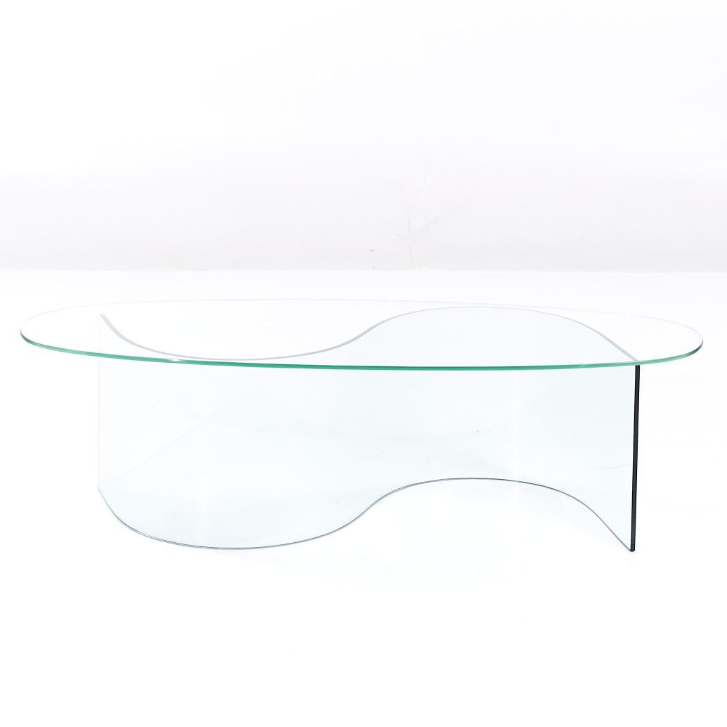 Table basse en verre S du milieu du siècle				
					
Cette table basse mesure : 59.25 de large x 19.5 de profond x 16.25 de haut

Tous les meubles peuvent être achetés dans ce que nous appelons un état vintage restauré. Cela signifie que la pièce