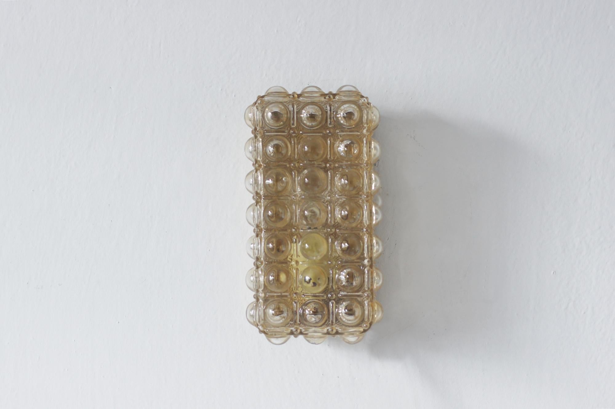 Le plafond des années 1960, avec son verre irisé et son motif de bulles géométriques, est un exemple frappant de l'éclairage décoratif de l'ère du modernisme, dans lequel la forme fonctionnelle est combinée à une esthétique originale de la matière