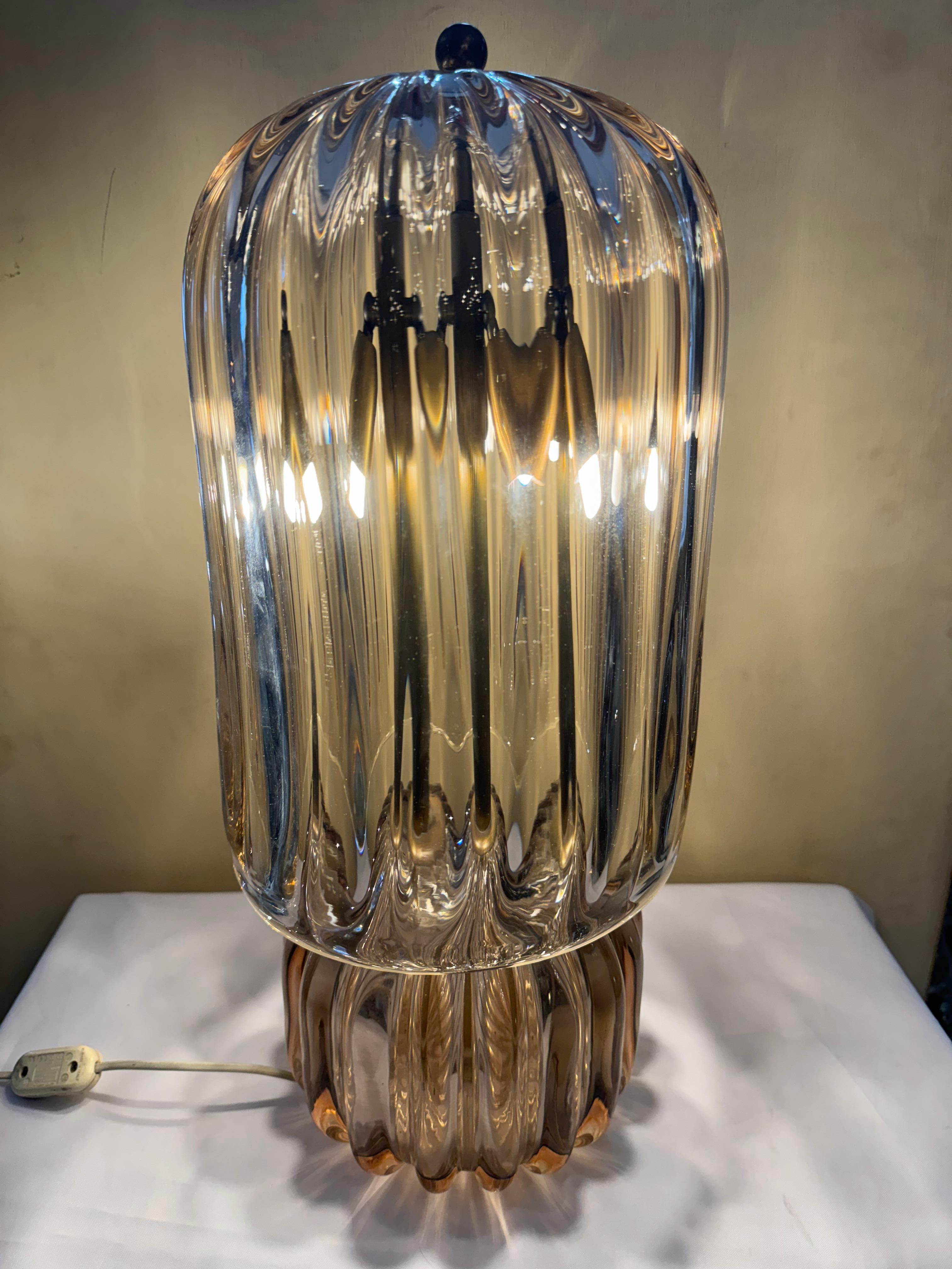 This exquisite mid-century modern glass lamp epitomizes the era's fascination with sleek, functional design and the innovative use of materials. Crafted from high-quality glass, its base boasts a stunning transparency that captures and refracts