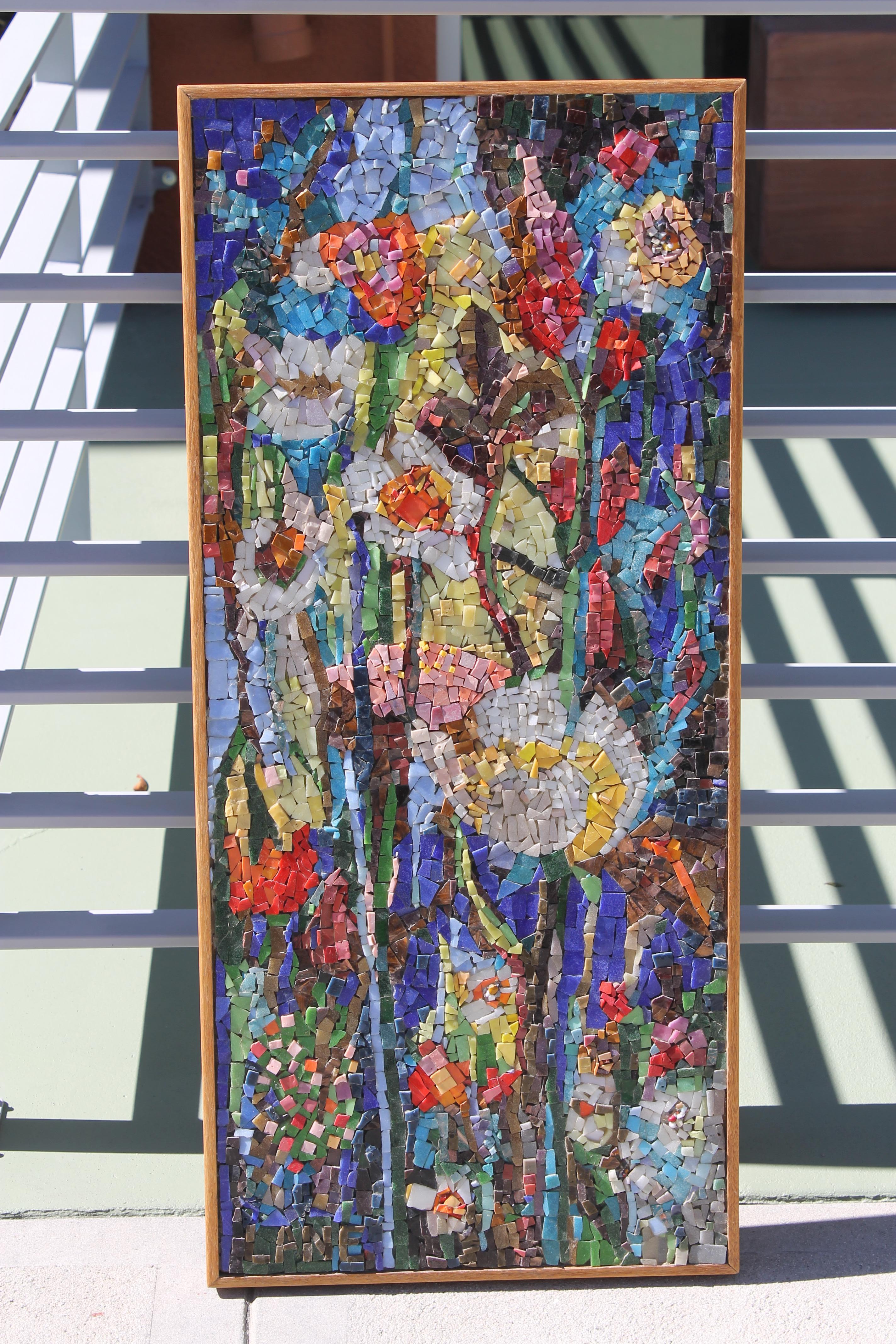 An extremely colorful and well-crafted mosaic of glass tesserae depicting a garden of wild flowers. The mosaic retains its original wood frame and is signed LANE in the lower left. Measurements are 16.5