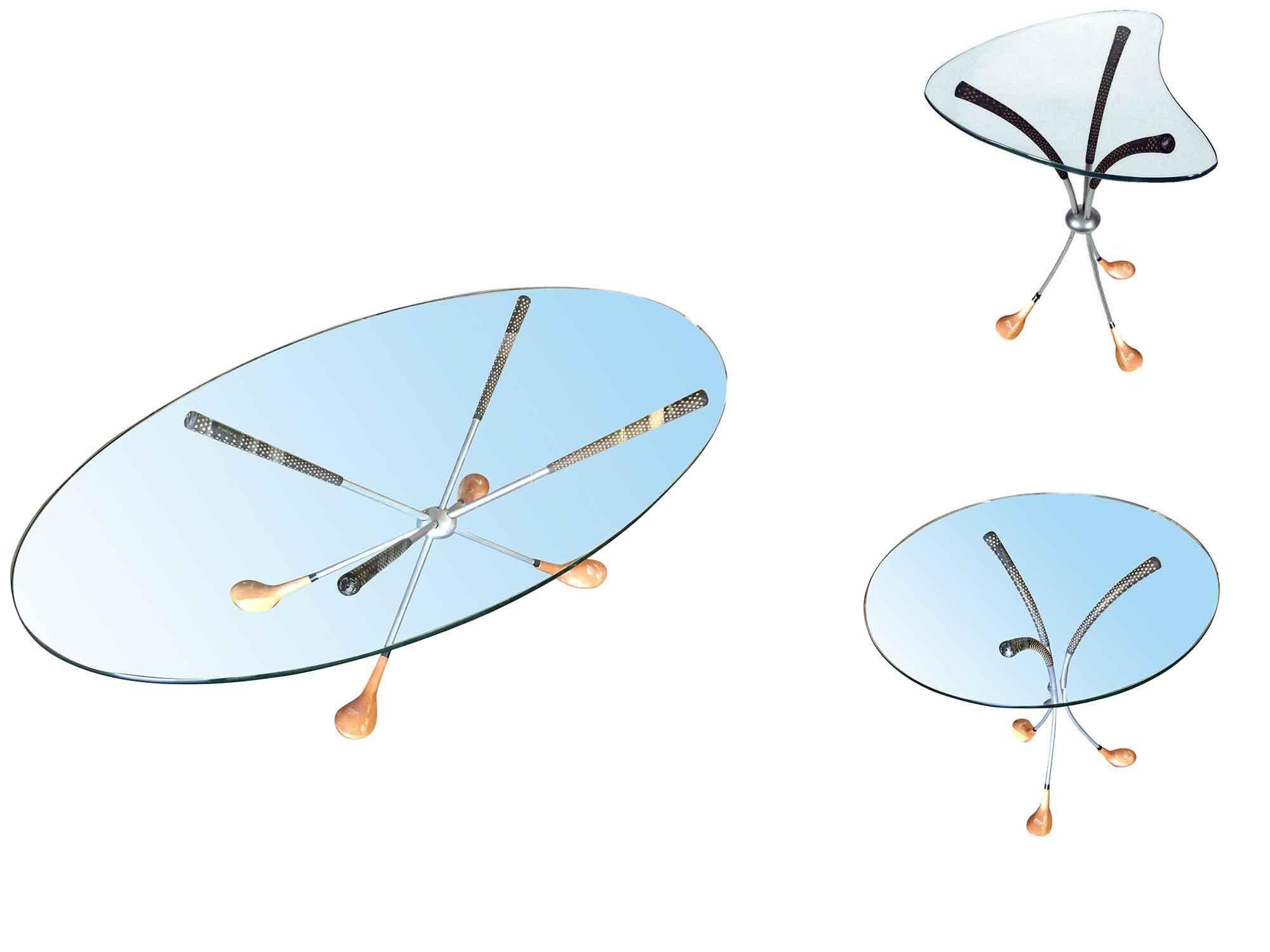 Playful coffee table and end table set by Clubhouse Design features a quarter-inch thick glass top resting on a base of three to four real wood driver clubs. This set includes a coffee table with an oval top, one end table with a biomorphic top and