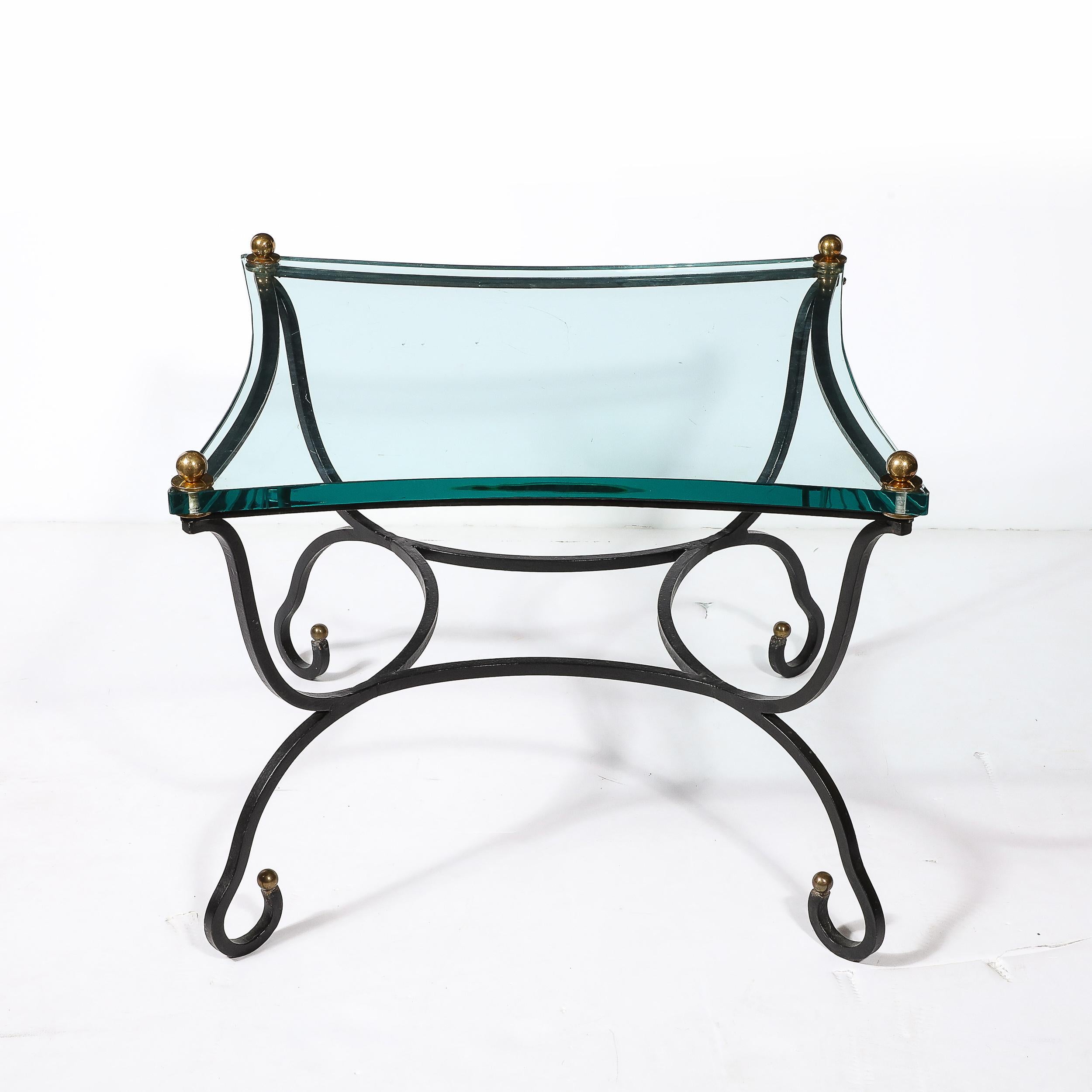 Questo esclusivo tavolino con piano in vetro del Mid-Century Modernist con base scultorea in bronzo e accessori in ottone proviene dalla Francia, circa dal 1950. Questo tavolo è caratterizzato da un sostanzioso piano in vetro con eleganti linee