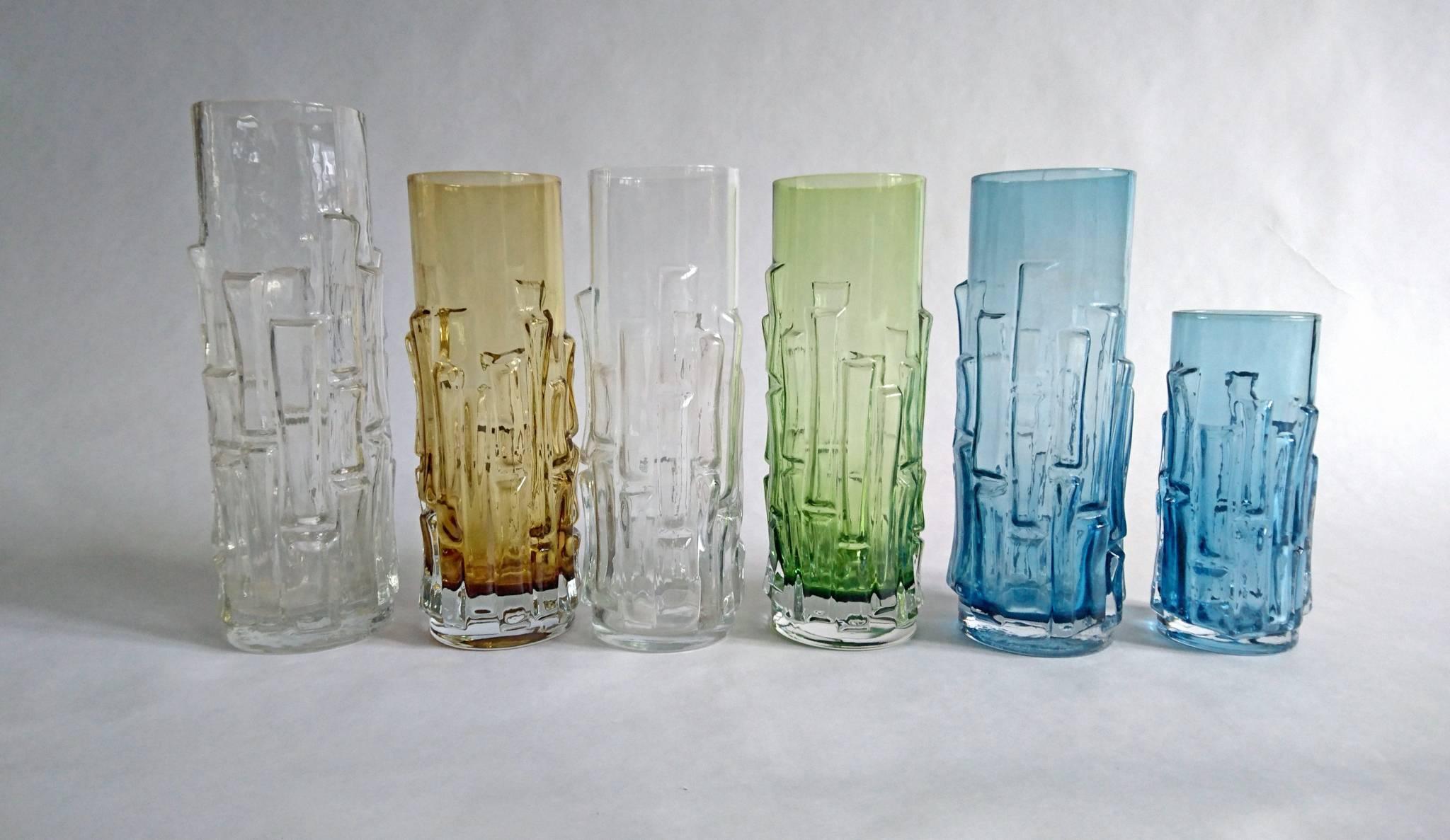 Six midcentury vases of different sizes by Aseda Glasbruk (glass makers) Sweden. In blue, green, amber and clear cased glass bamboo style. The name of the design is 'Bark' vase, designed by Bo Borgstrom.
The tallest clear vase is 24 cm tall,