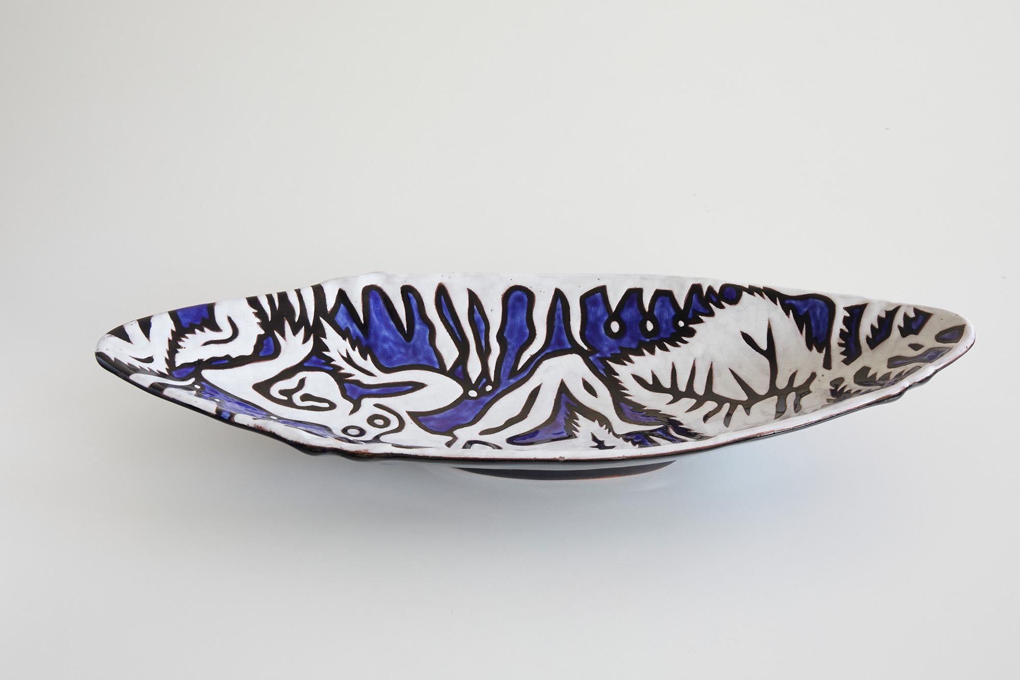 Large bowl or vessel by Jean Lurçat (1892-1962)
Ed. Sant-Vicens, France around 1950

The blue and white hand painted vessel depicts a vibrant naturalistic scene of a reclining woman on a blue background composed of leaves and branches. 

From an
