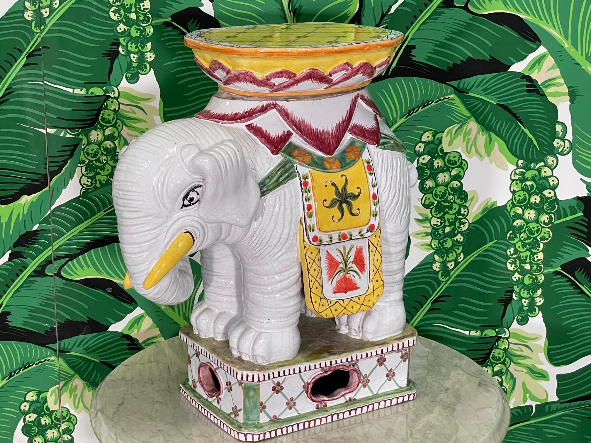 Siège de jardin pour éléphant en céramique peint à la main, pouvant être utilisé comme table d'appoint ou pouf, fini en blanc brillant avec des couleurs d'accentuation vibrantes. Bon état avec des imperfections mineures correspondant à l'âge, voir