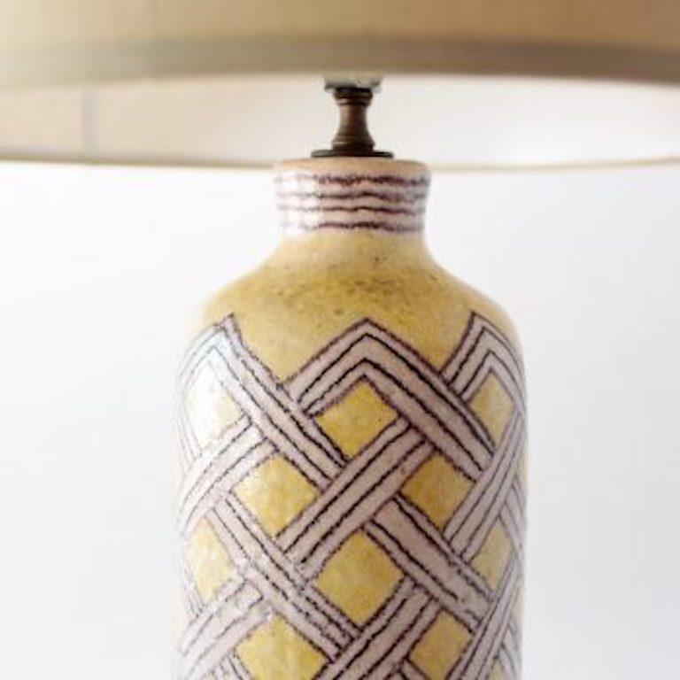 Glazed ceramic table lamp with hand-decorated lattice design. Lemon yellow and lavender-gray. New linen shade and rewired with brown nylon cord. Signed 
