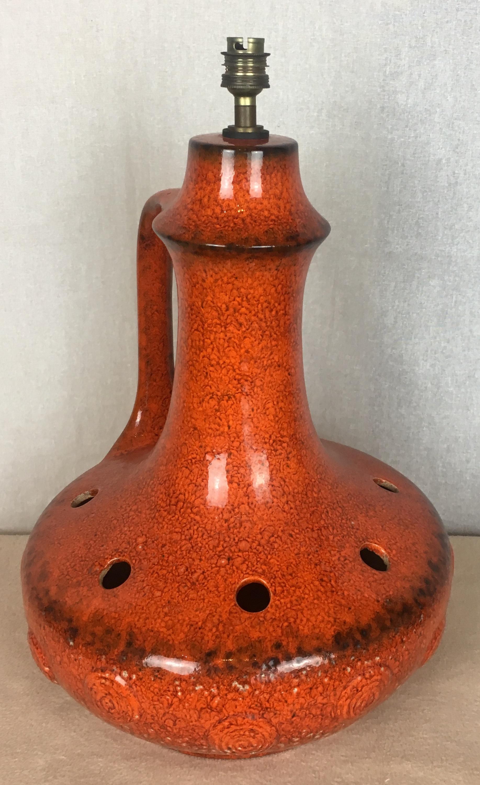 Very decorative and large Mid-Century Modern table lamp in a stunning glazed burnt orange ceramic with brown hues. Originates from Vallauris, France. 

The base has many very attractive details and a unique, sophisticated form. Its glamorous