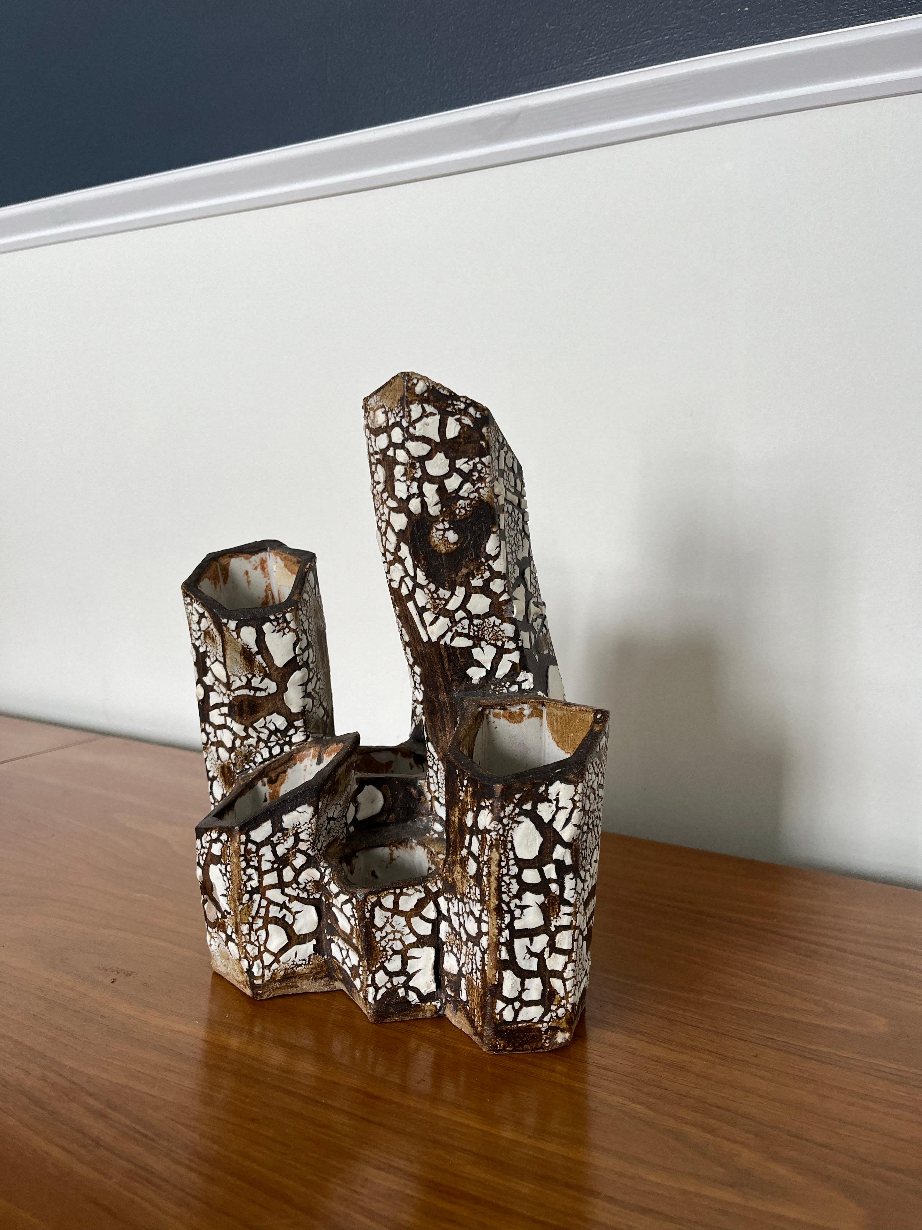 Vaso scultura in ceramica dalla struttura unica, composto da tubi esagonali. Superficie strutturata come lava bianca o corteccia sovrapposta al marrone. Le angolazioni variabili mantengono l'occhio in movimento.