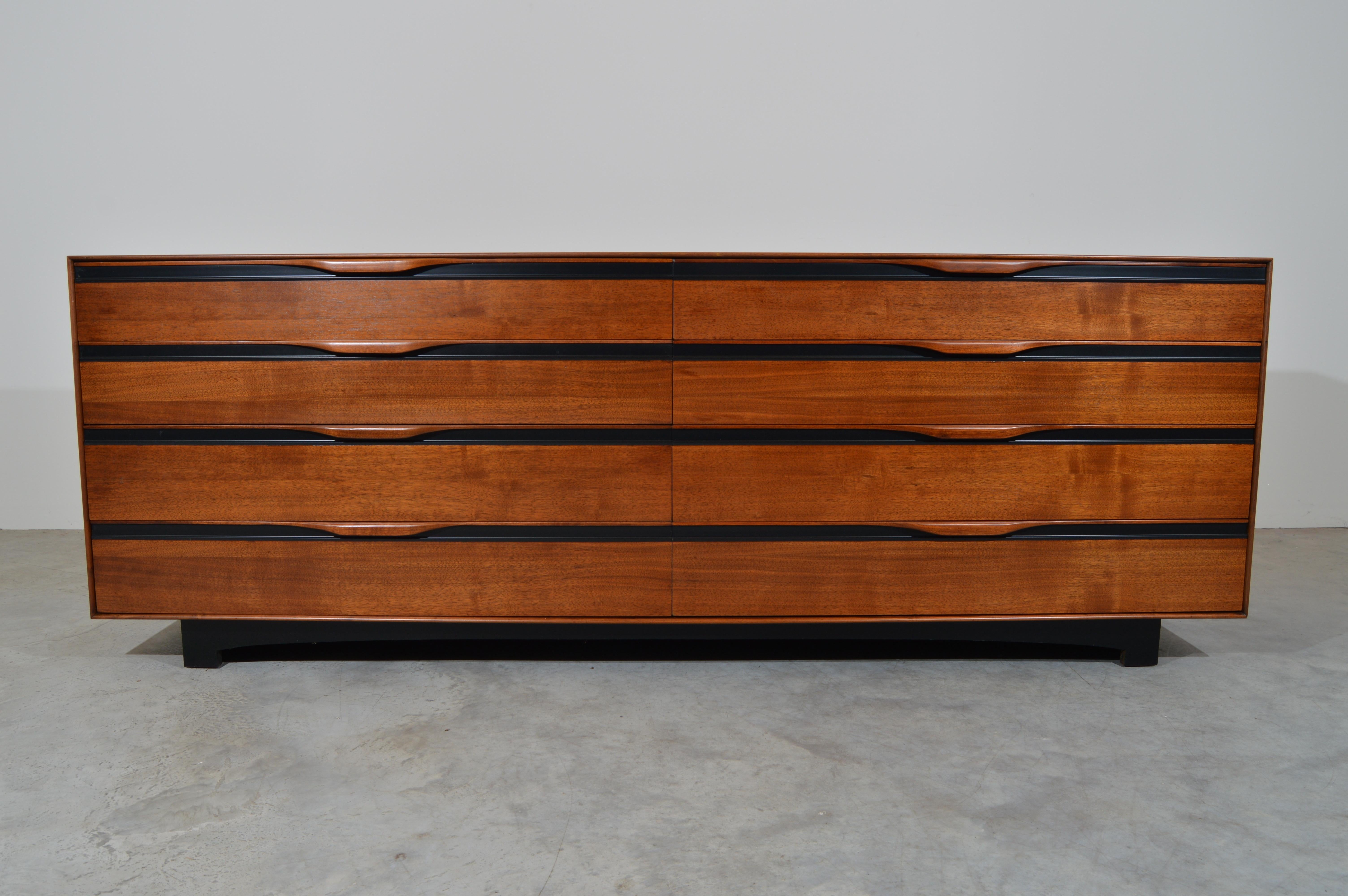 A beautiful mid-century walnut 8 drawer dresser having sculptural pulls with contrasted ebony accents throughout designed by John Kapel for Glenn of California. The drawers feature fully adjustable dividers so you can set them up however you like.